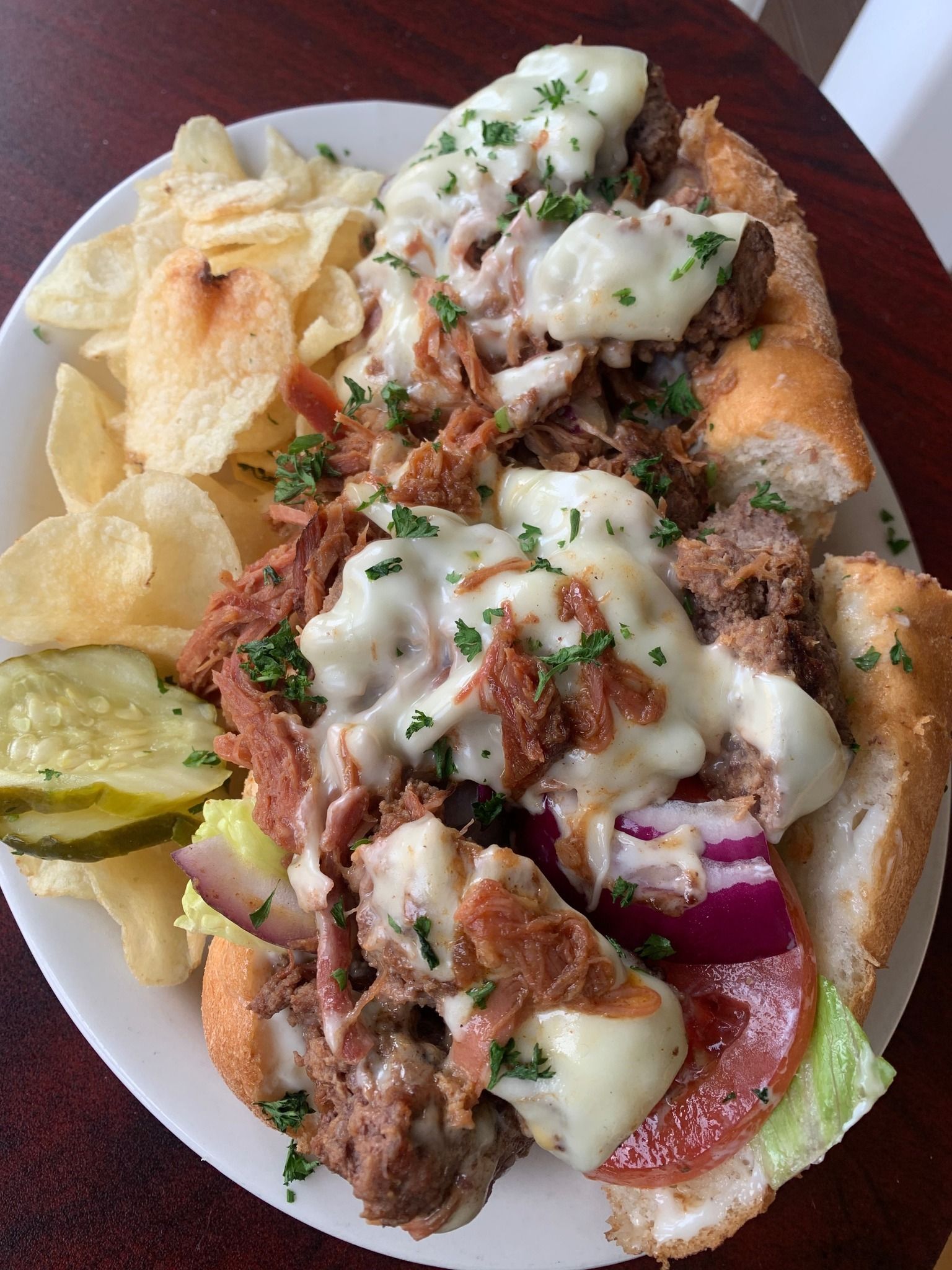 A plate of food with a sandwich and chips on a table.