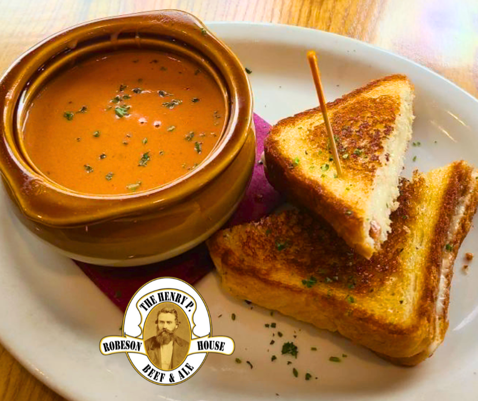 A bowl of soup next to a plate of grilled cheese