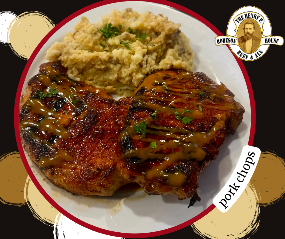 A white plate topped with pork chops and mashed potatoes