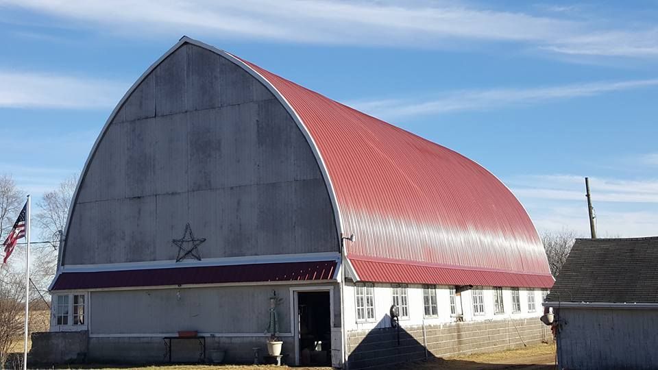 Barn reroofing project with red metal roofing