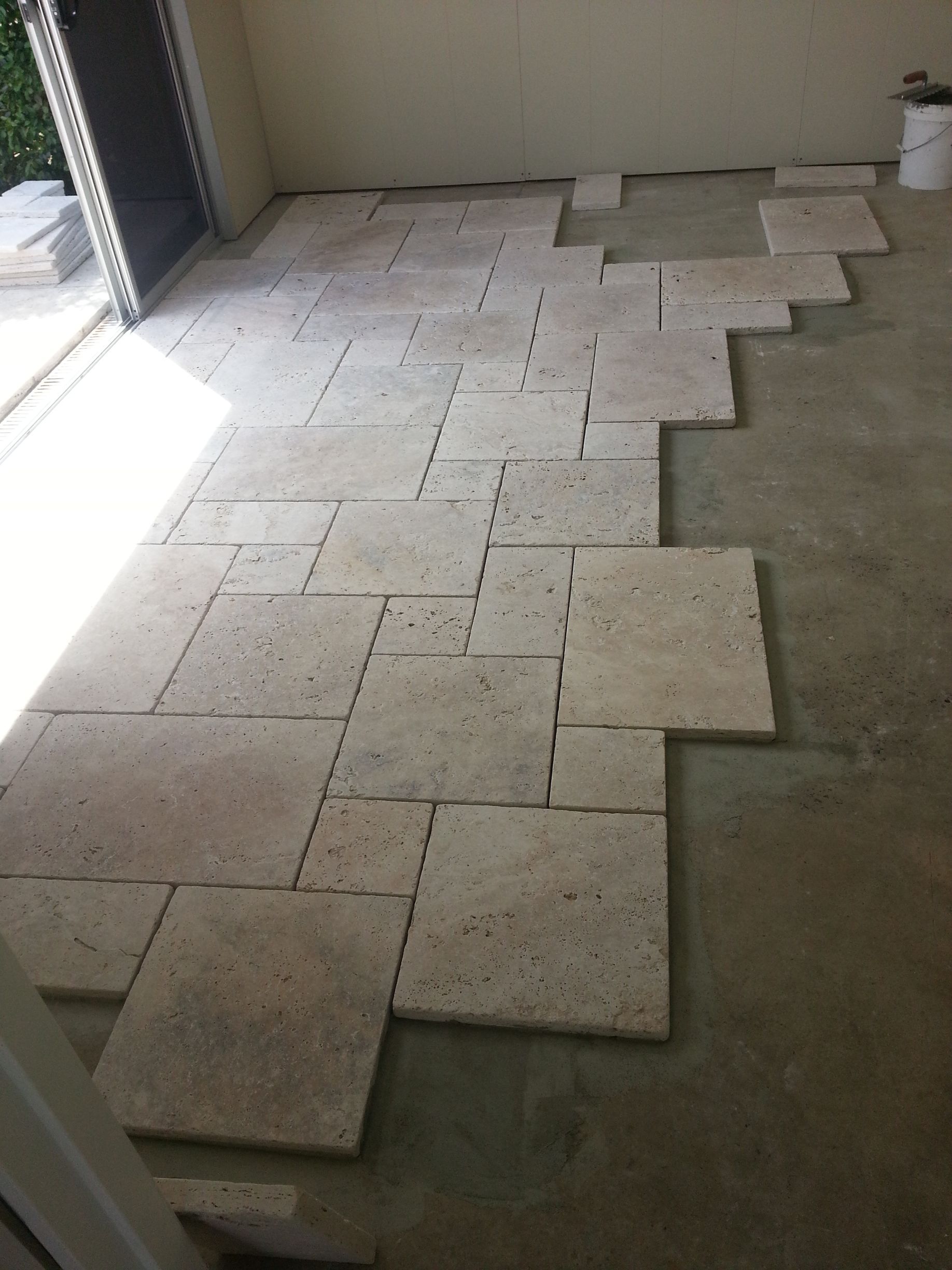 A Person is Laying a Tile on the Floor — South Coast Flooring in Berkeley, NSW