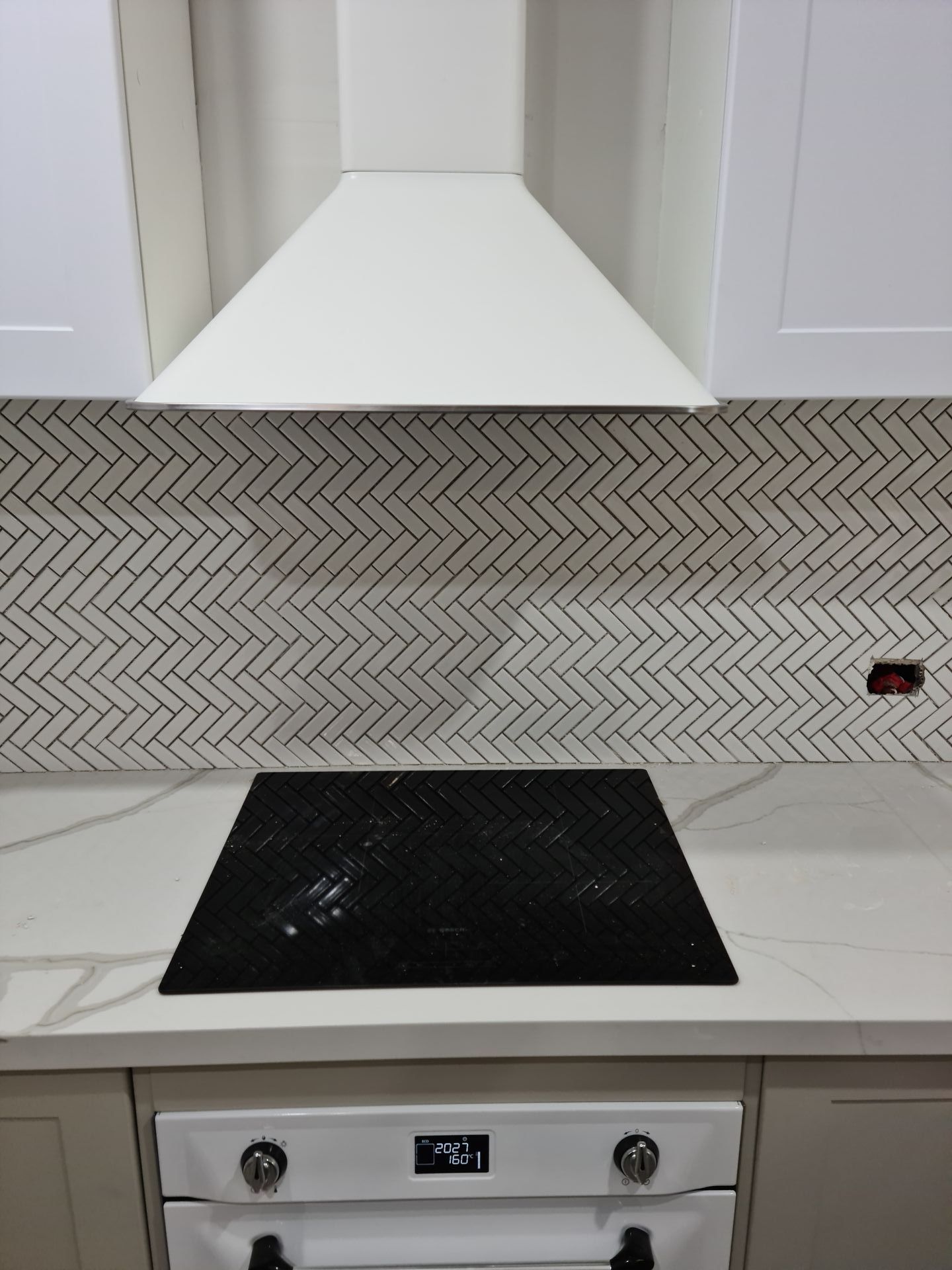 A kitchen with a stove top oven and a hood — South Coast Flooring in Berkeley, NSW