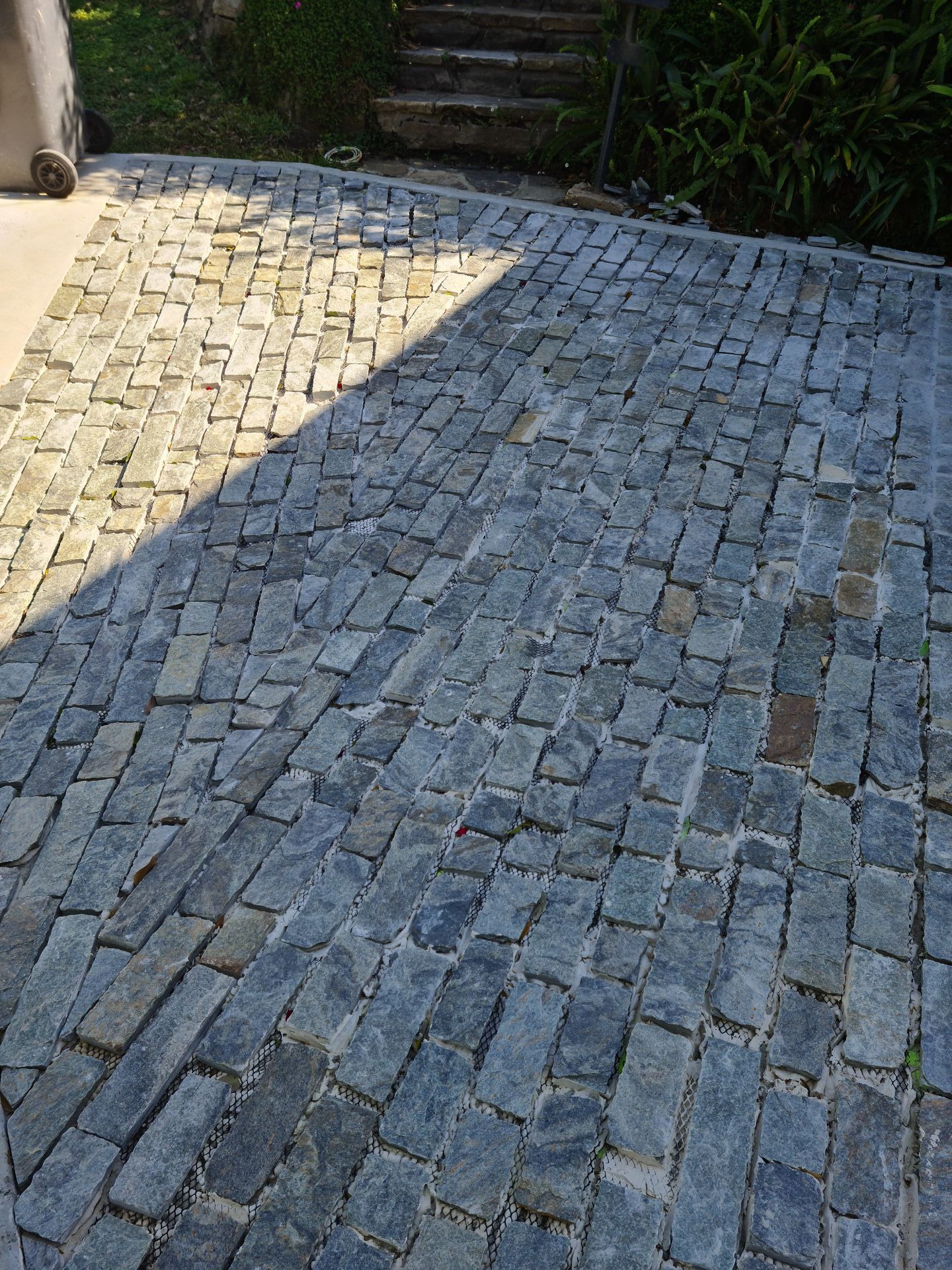 A cobblestone driveway with a trash can in the background — South Coast Flooring in Berkeley, NSW