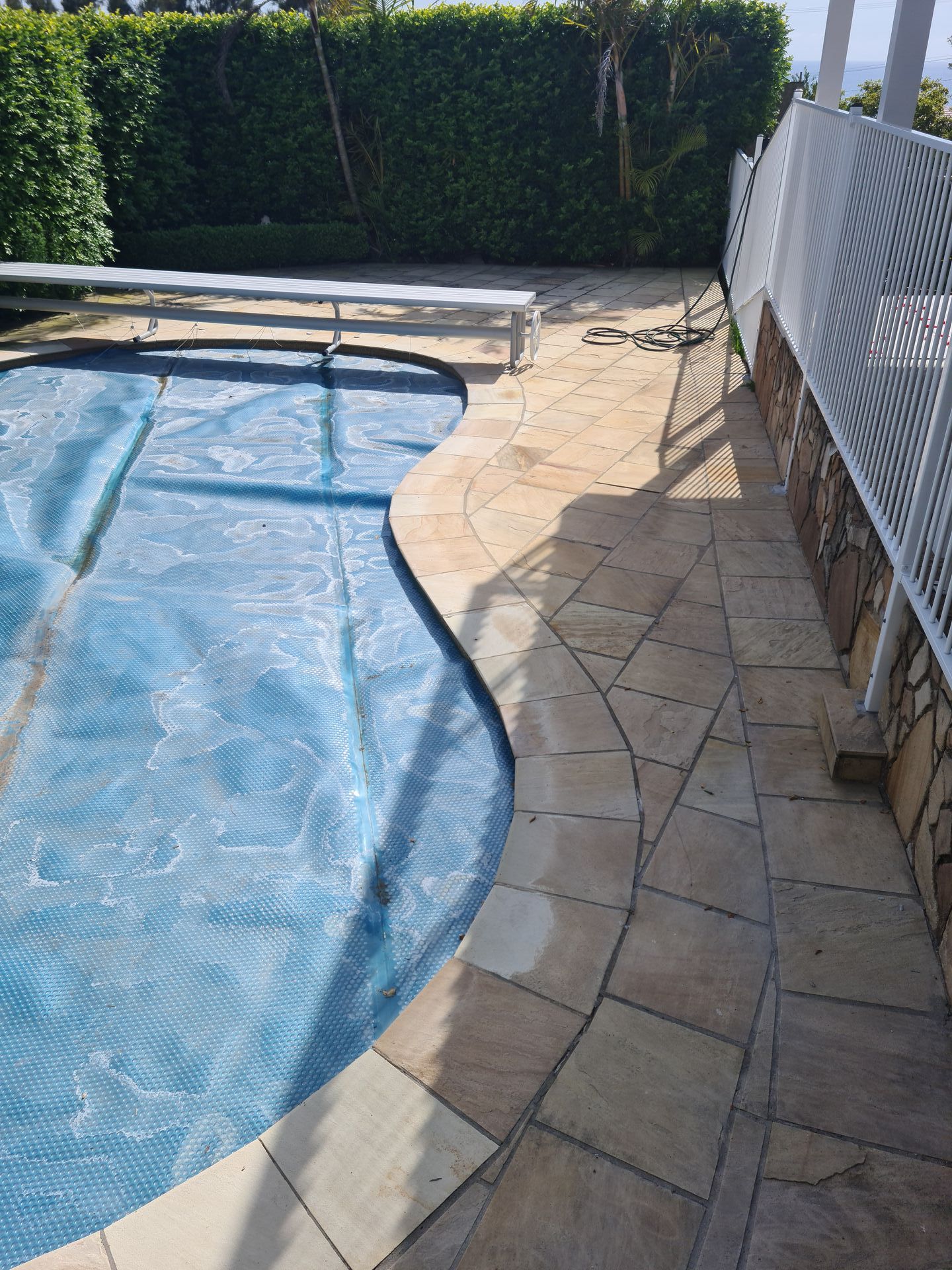 A large swimming pool with a blue cover on it — South Coast Flooring in Berkeley, NSW