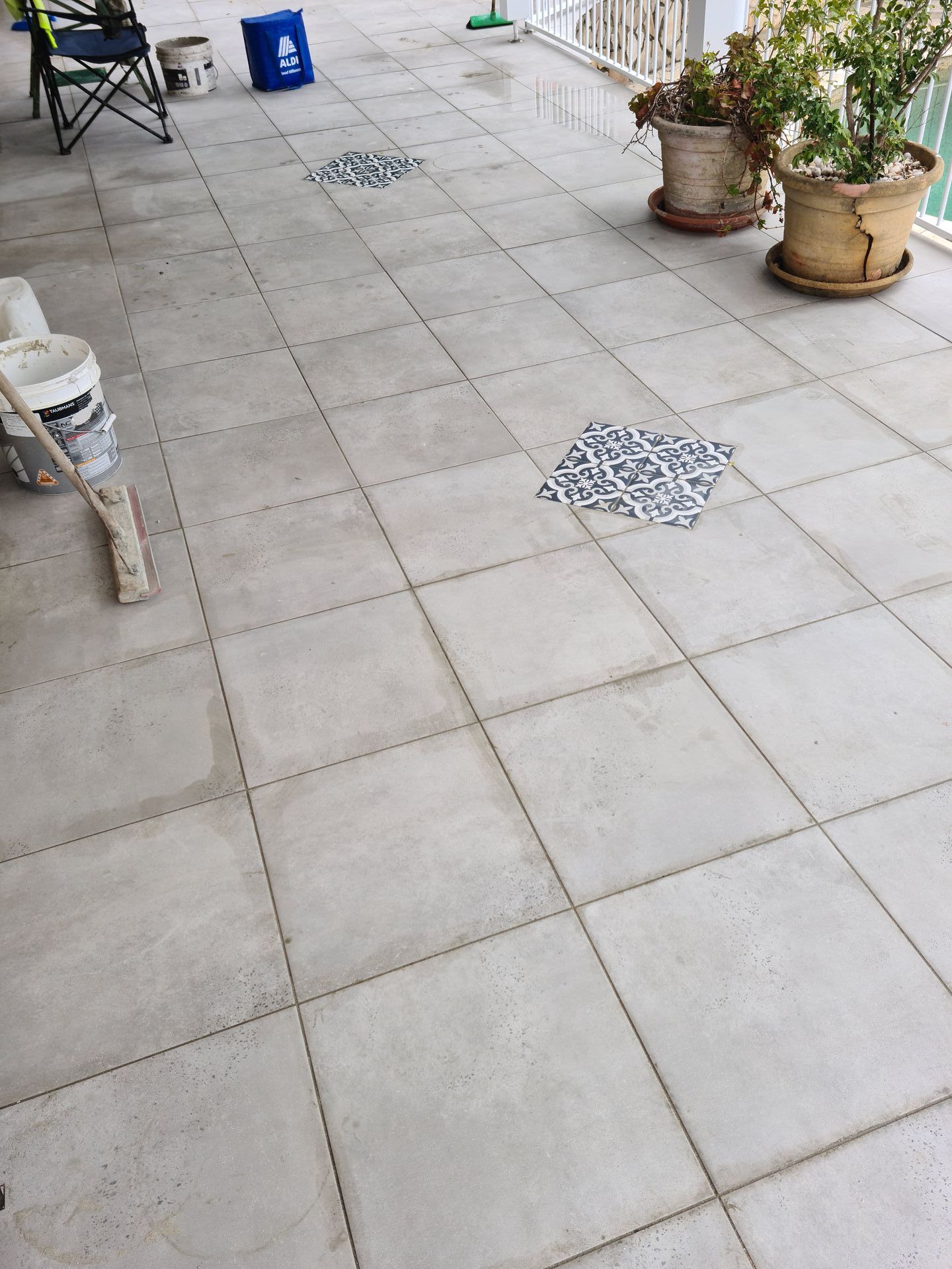 A patio with tiles and potted plants on it — South Coast Flooring in Berkeley, NSW