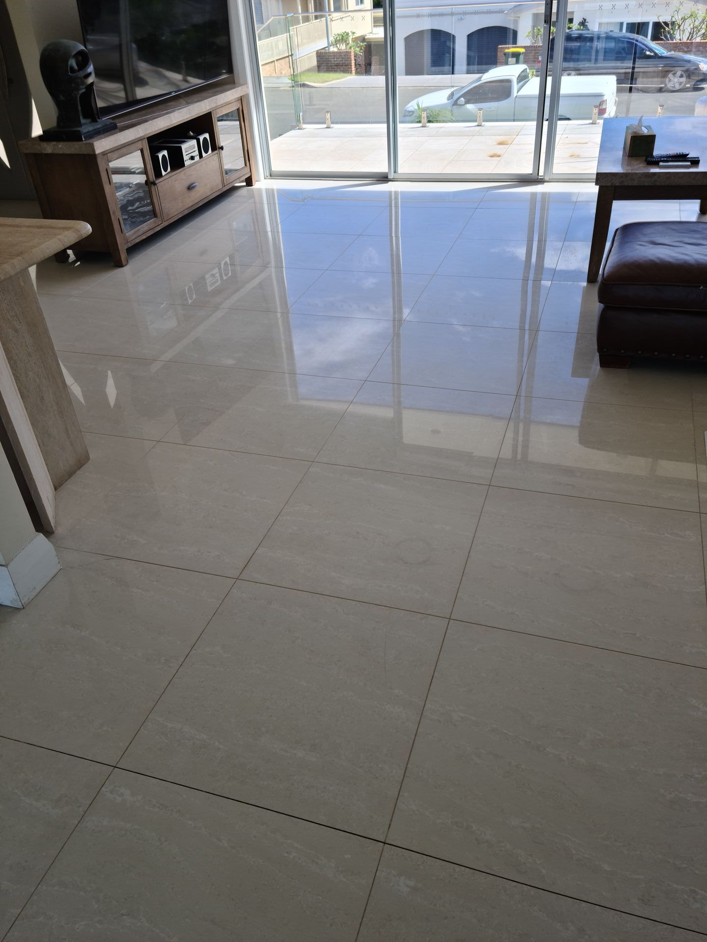 A living room with a marble floor and a sliding glass door — South Coast Flooring in Berkeley, NSW