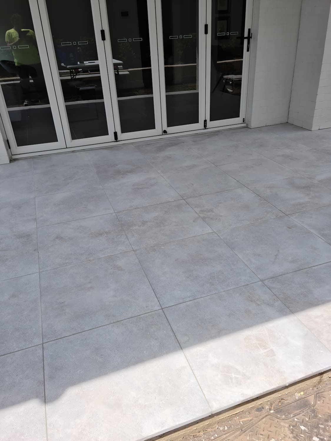 A Tiled Floor in Front of a Building With Sliding Glass Doors — South Coast Flooring in Berkeley, NSW