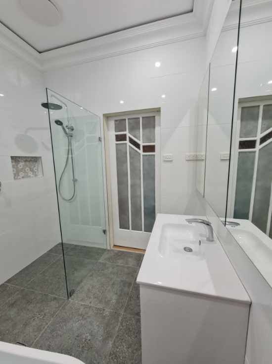A bathroom with a sink and a walk in shower — South Coast Flooring in Berkeley, NSW