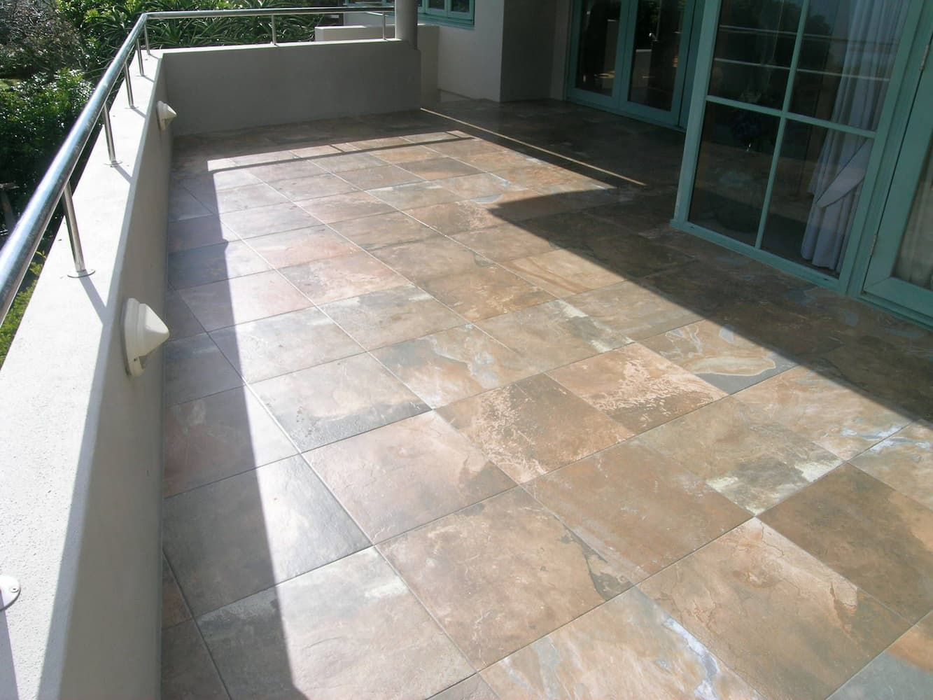 A Balcony With a Tiled Floor and a Railing — South Coast Flooring in Kiama, NSW