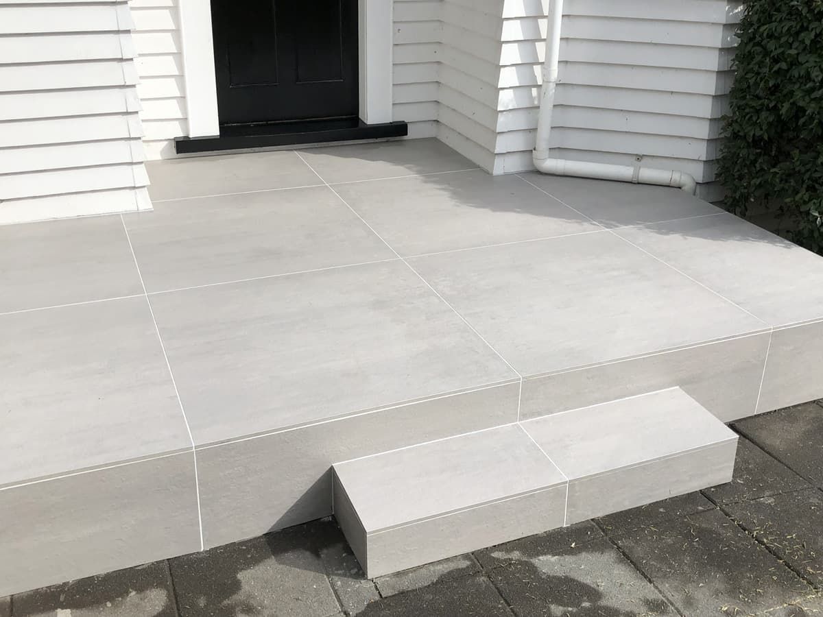 A White Tiled Porch With Steps Leading to a Door — South Coast Flooring in Kiama, NSW