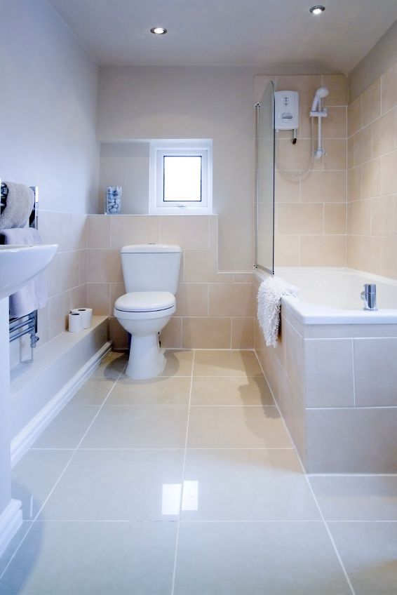 A bathroom with a toilet , sink and bathtub — South Coast Flooring in Berkeley, NSW