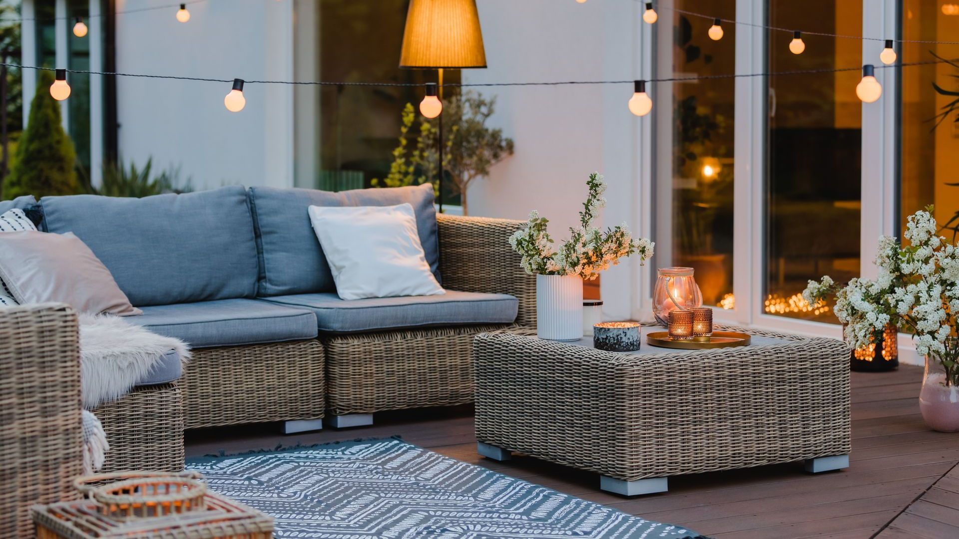 Un patio avec un canapé, des chaises et une table.