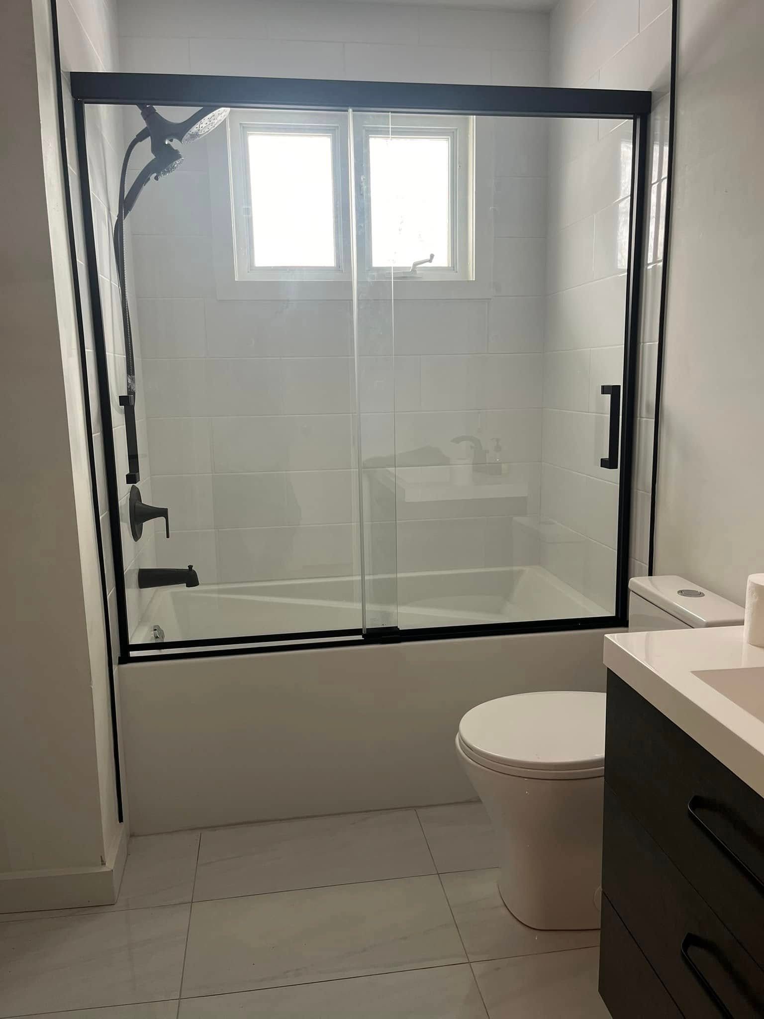 Une salle de bain avec baignoire, WC, lavabo et cabine de douche.