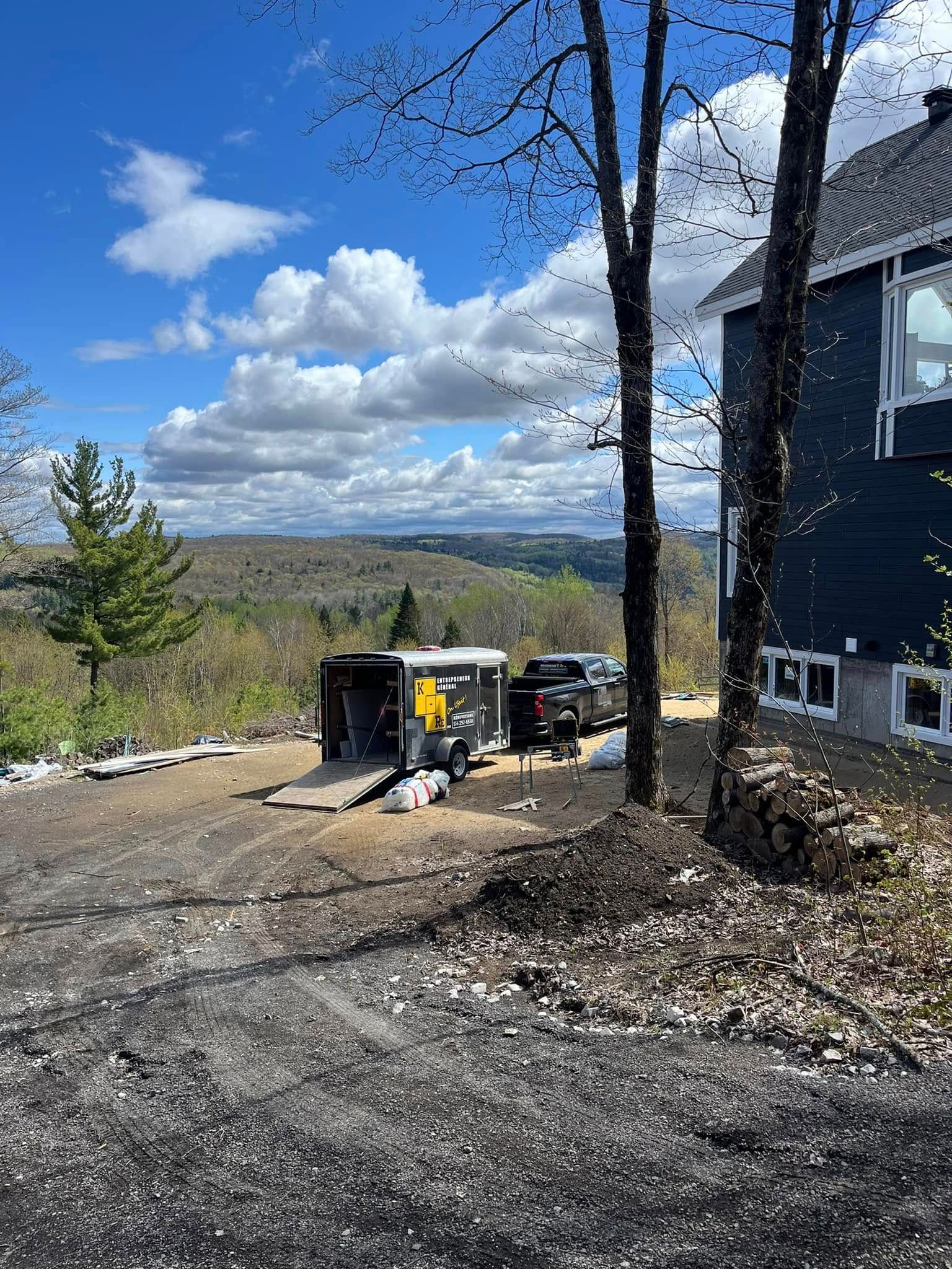 Un camion est garé devant une maison avec une remorque.