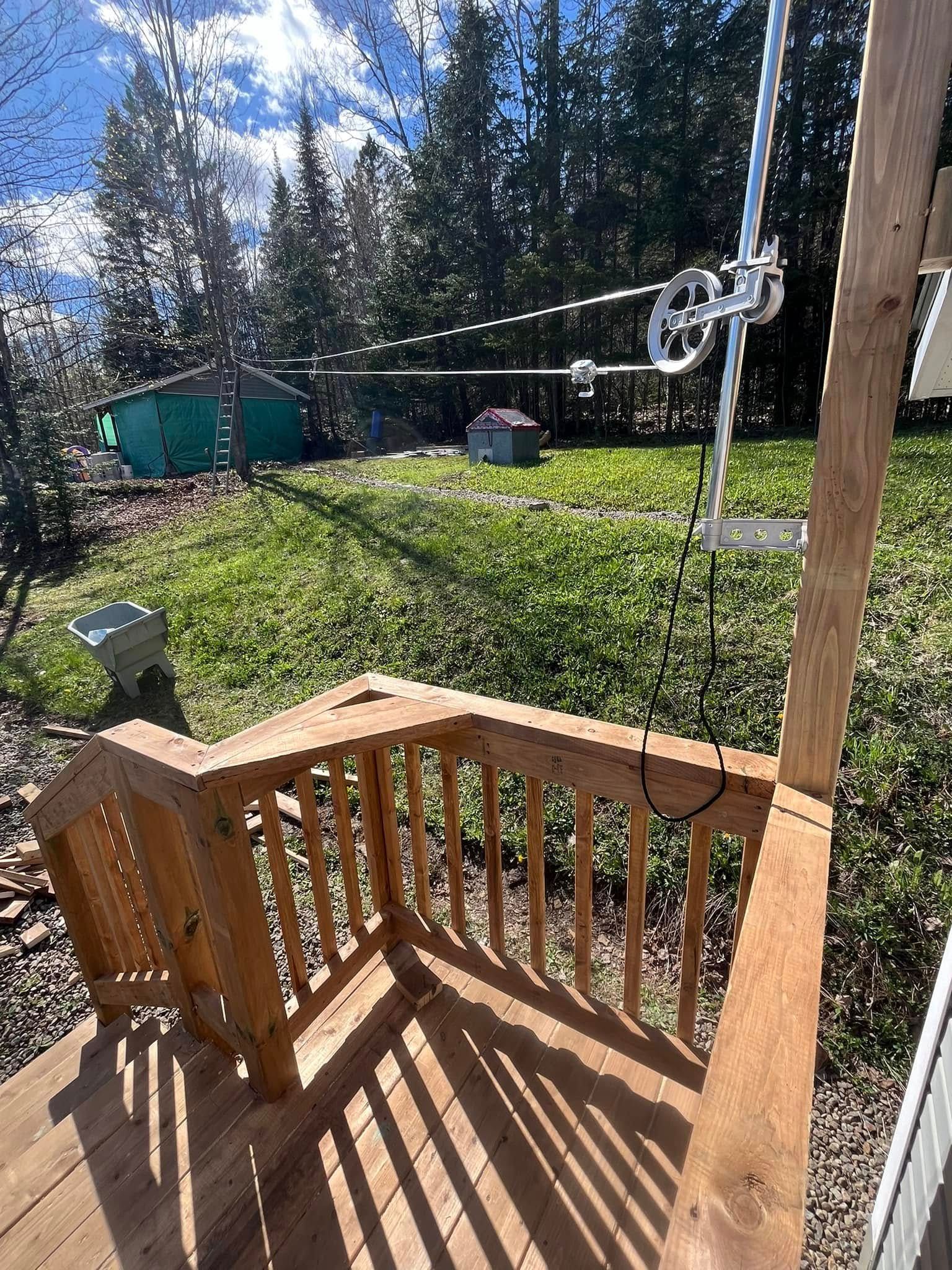 Une balançoire en bois est posée sur une terrasse en bois.