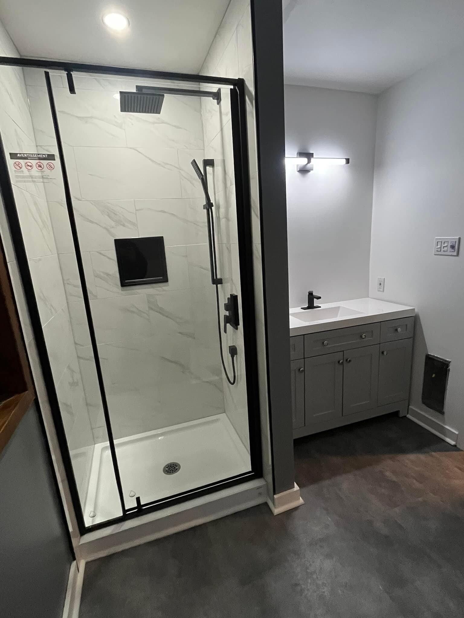 Une salle de bain avec une douche à l'italienne et un lavabo.