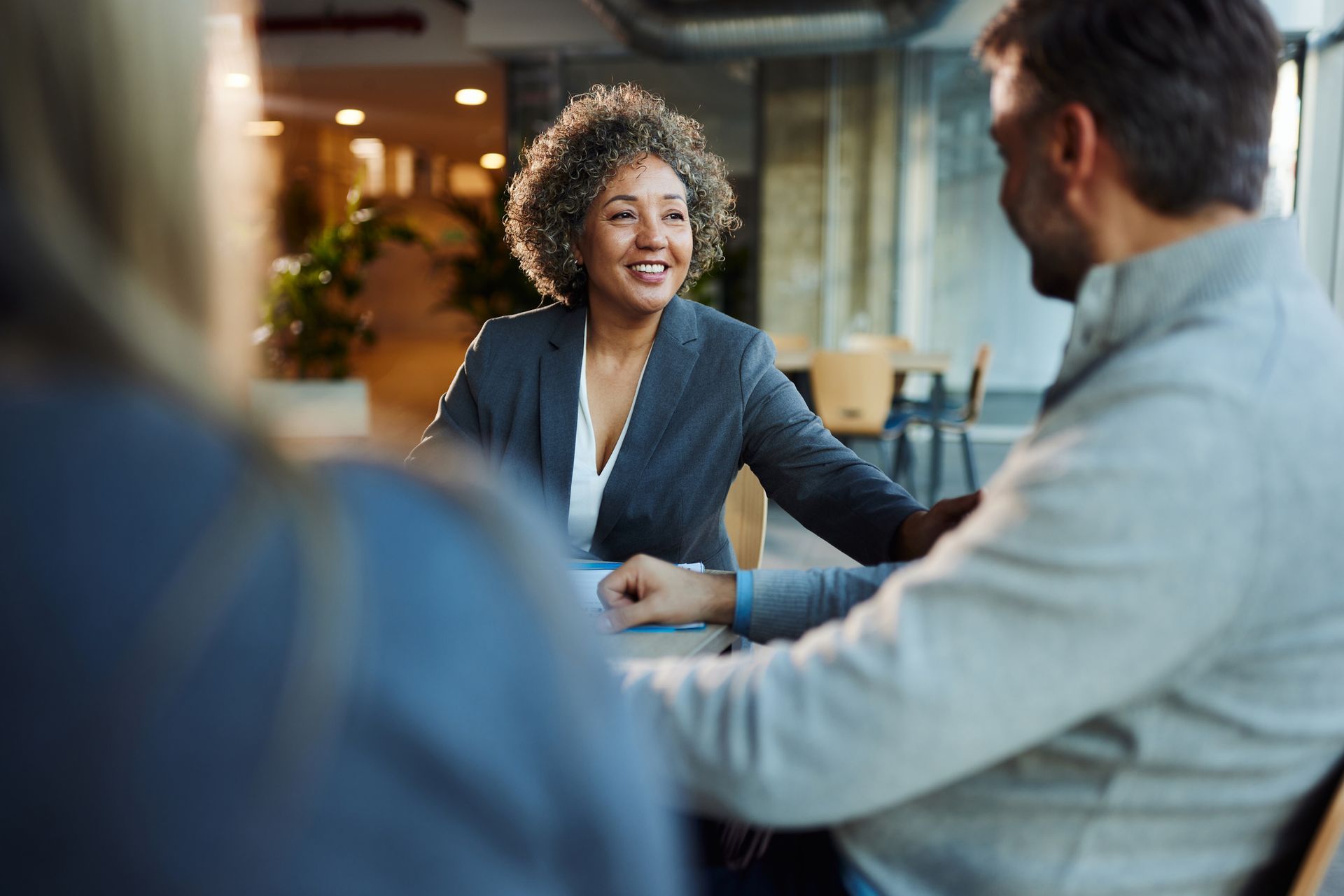 A happy insurance agent talking to a business owner in an office