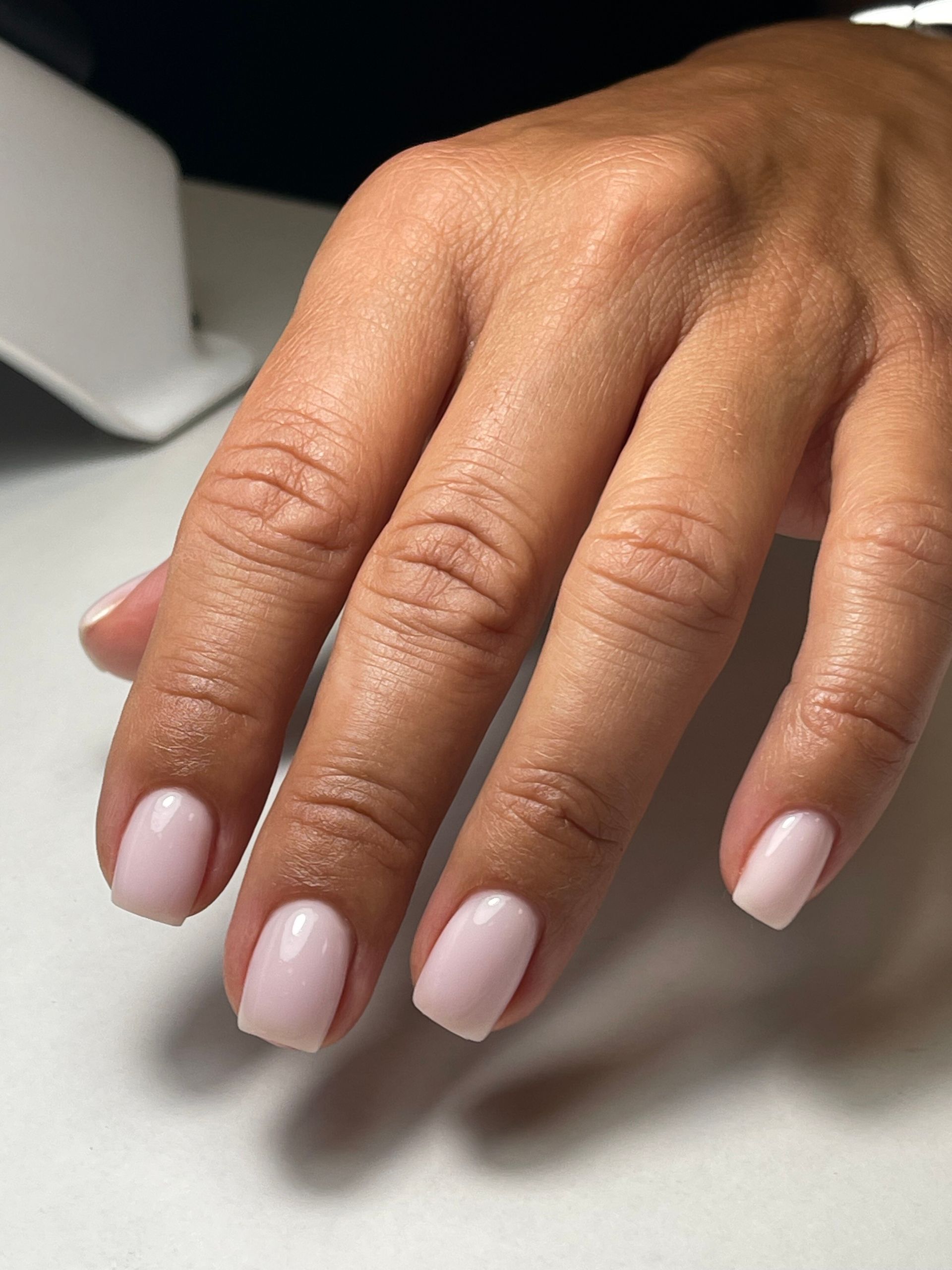 Eine Nahaufnahme einer Frauenhand mit rosa Nägeln