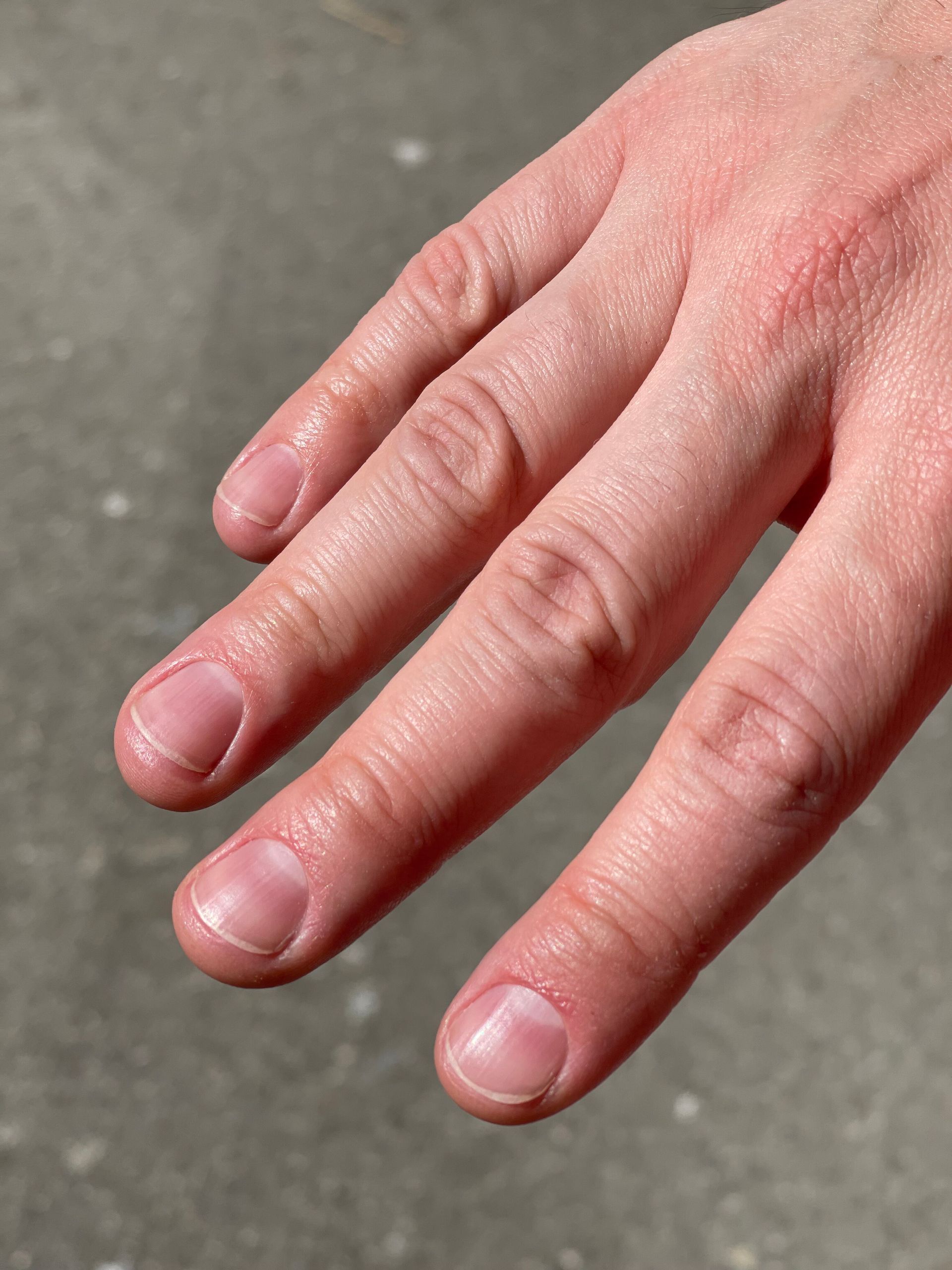 Eine Nahaufnahme der Hand einer Person mit rosa Nägeln