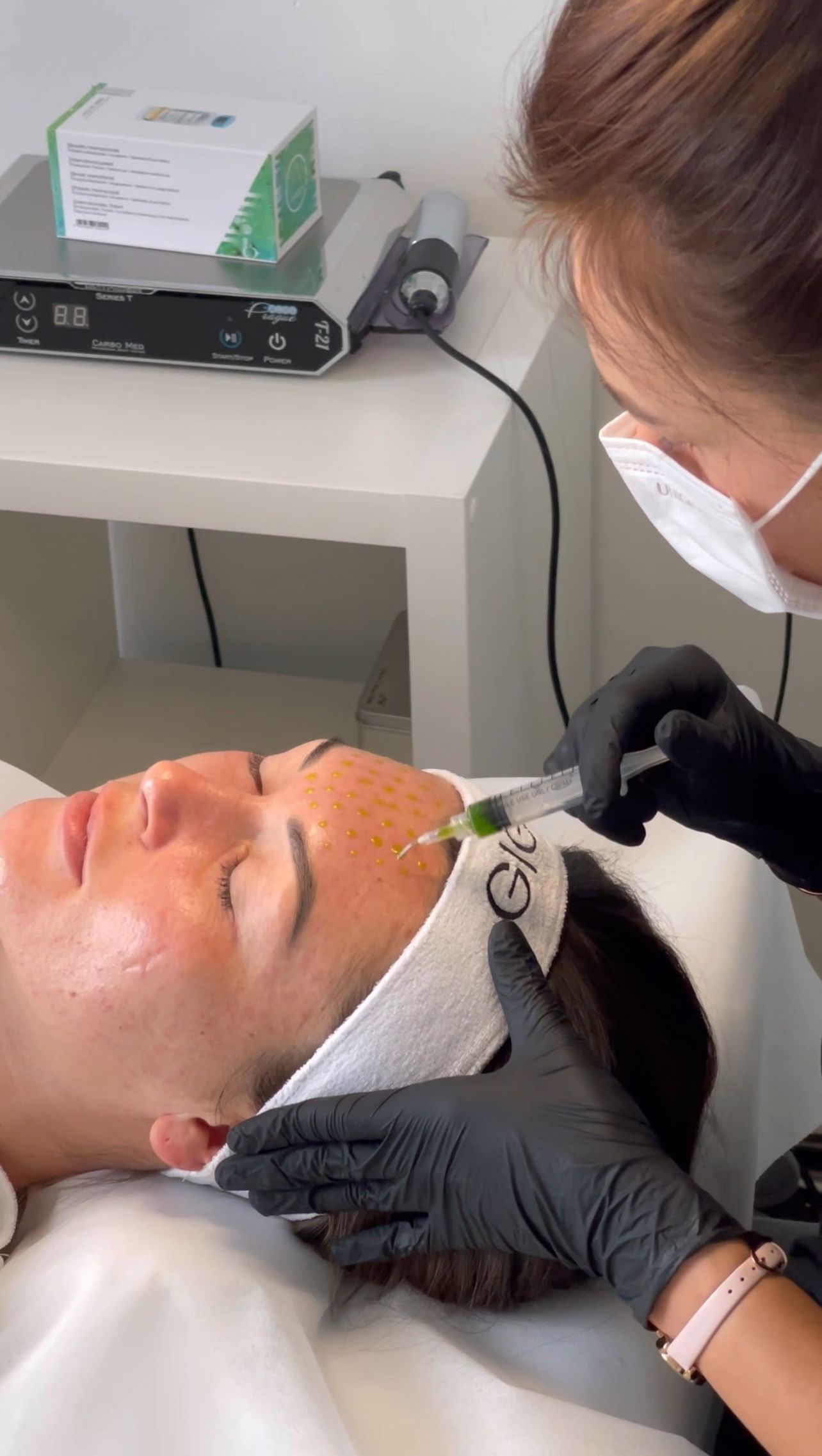 Eine Frau bekommt in einem Schönheitssalon eine Spritze ins Gesicht.