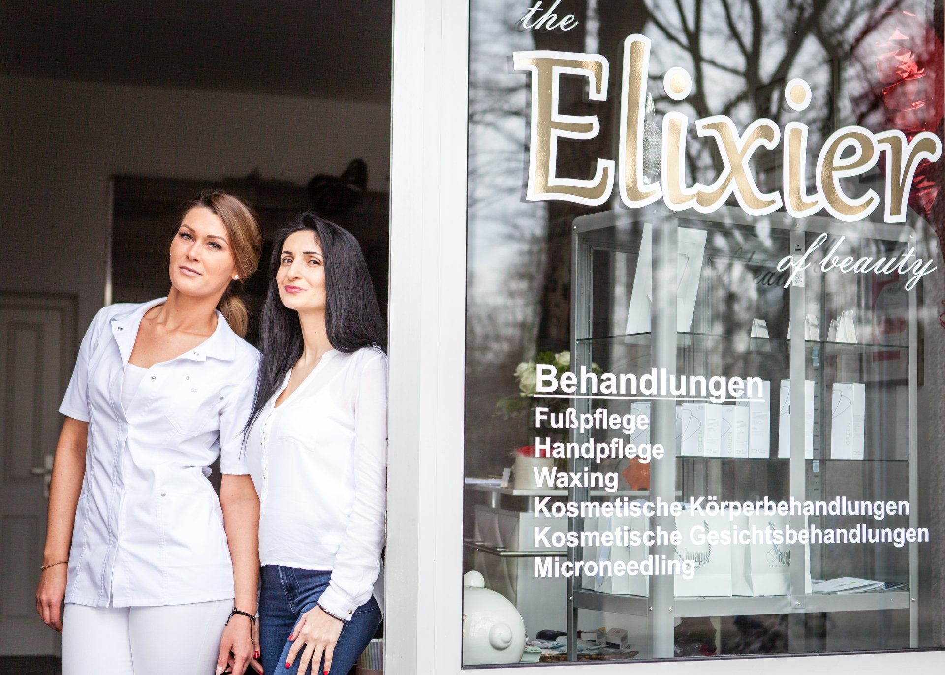 Zwei Frauen stehen vor dem Fenster eines Schönheitssalons.
