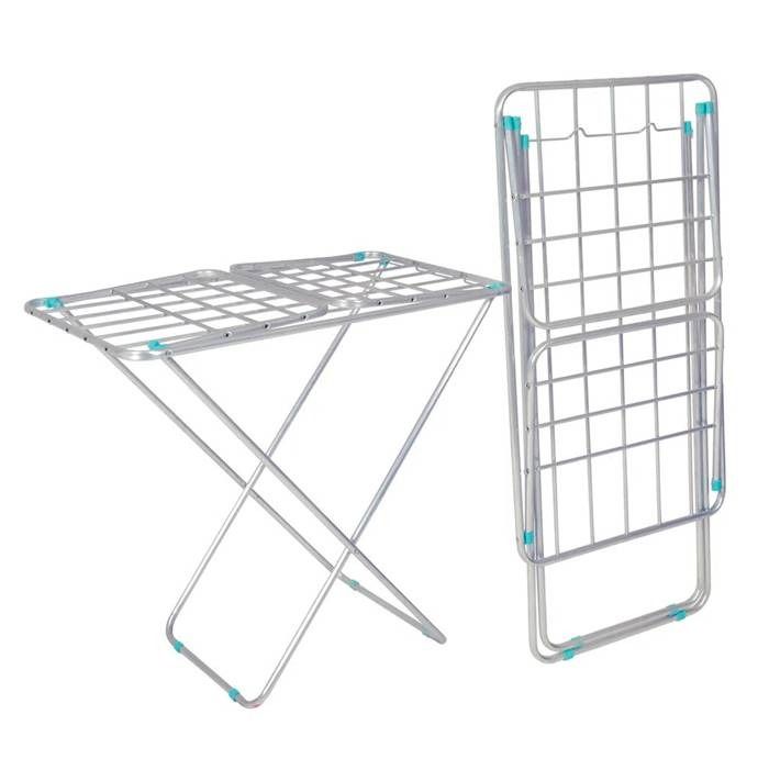 Un tendedero de ropa de metal está colocado encima de una mesa blanca.