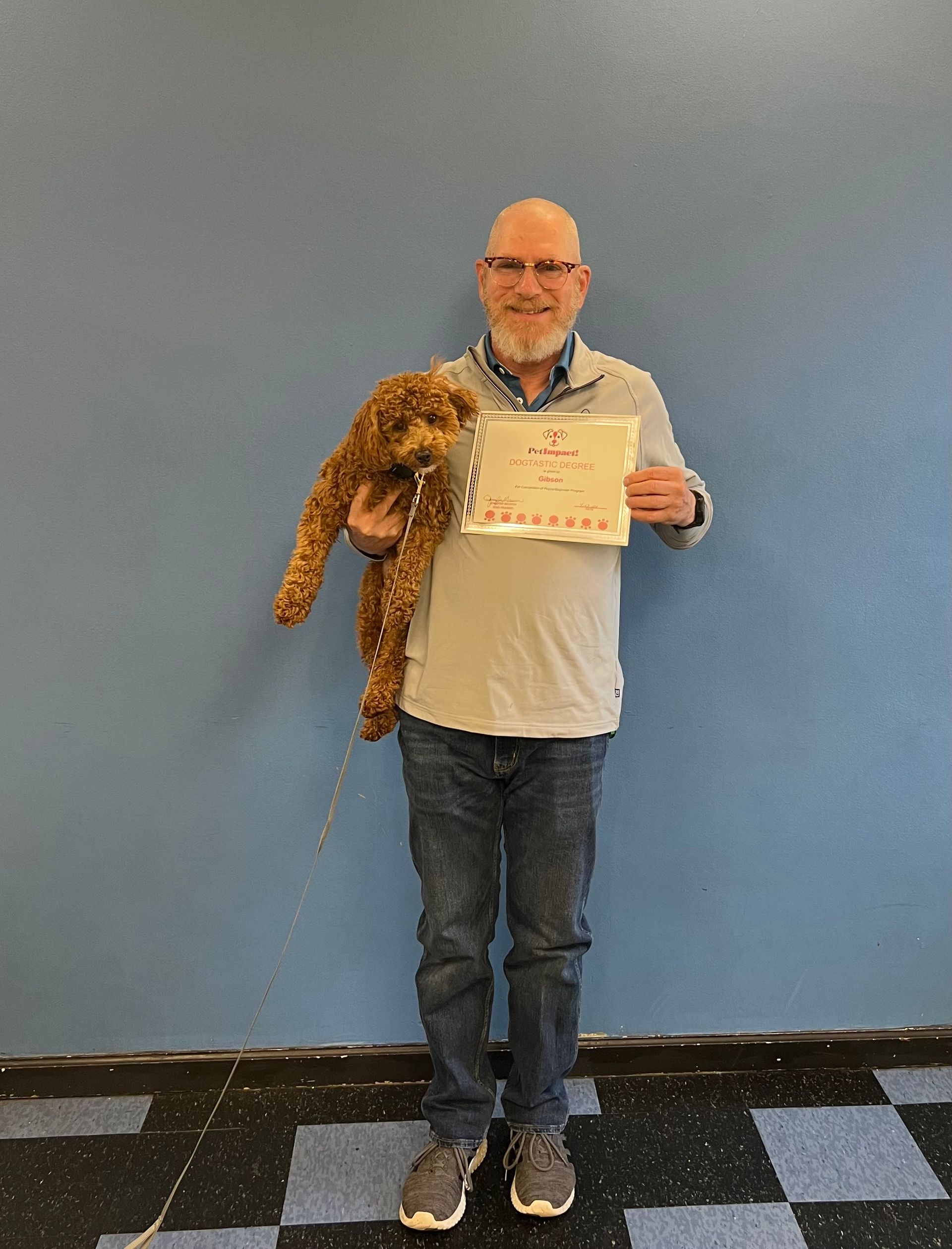 A man is holding a teddy bear and a certificate.