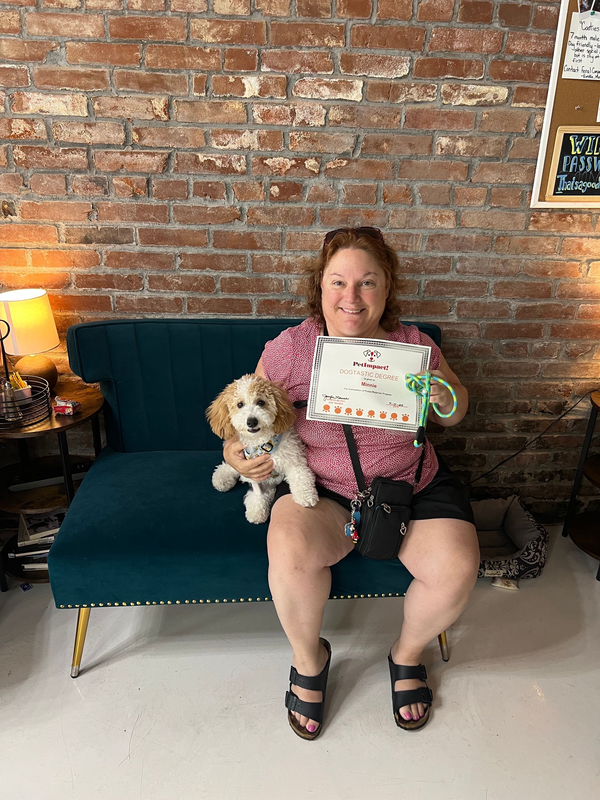 Woman Is Sitting on a Couch Holding a Dog and a Sign — St. Louis, MO — PetImpact!
