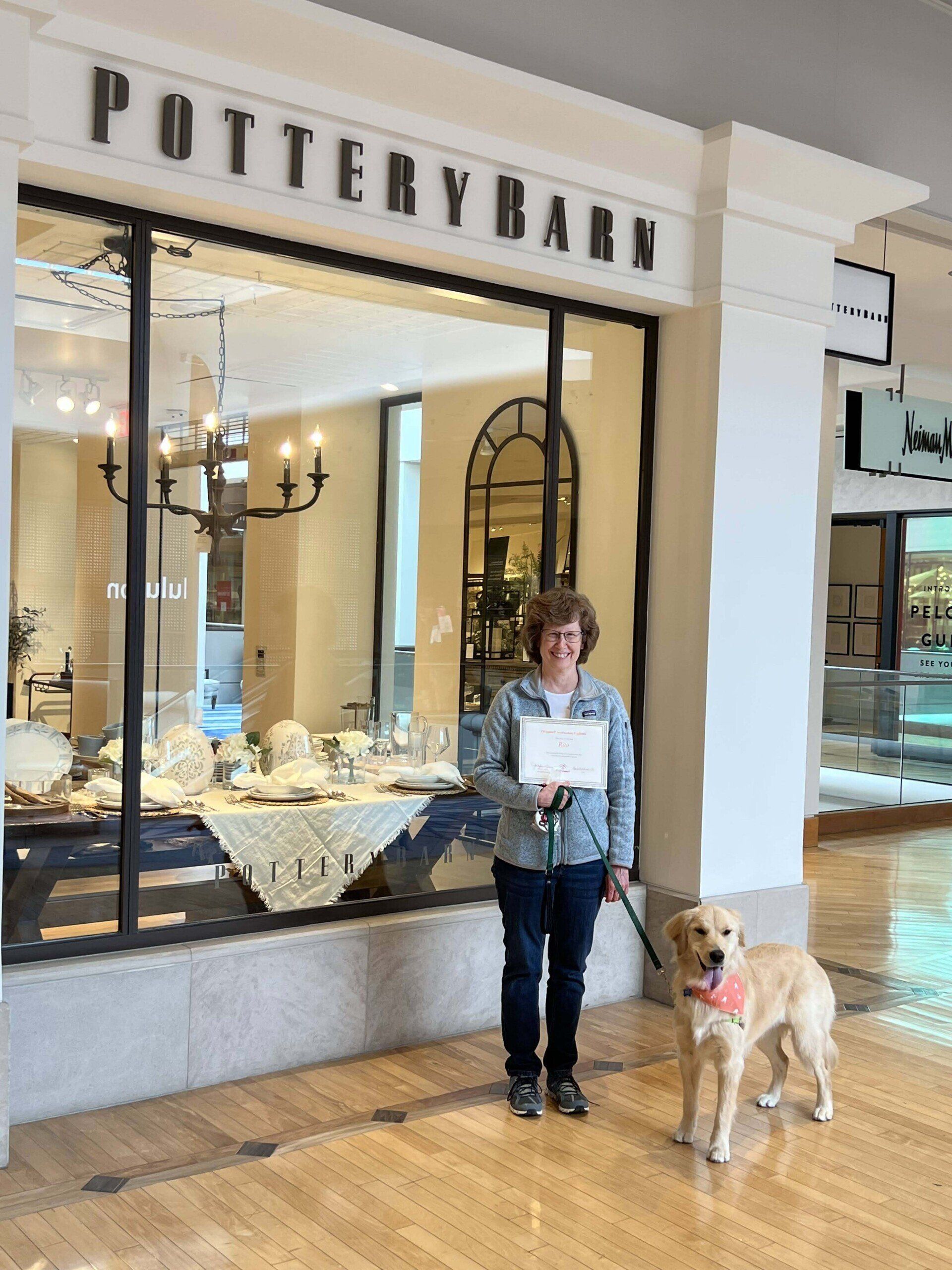 Woman and golden retriever dog outside Pottery Barn store.