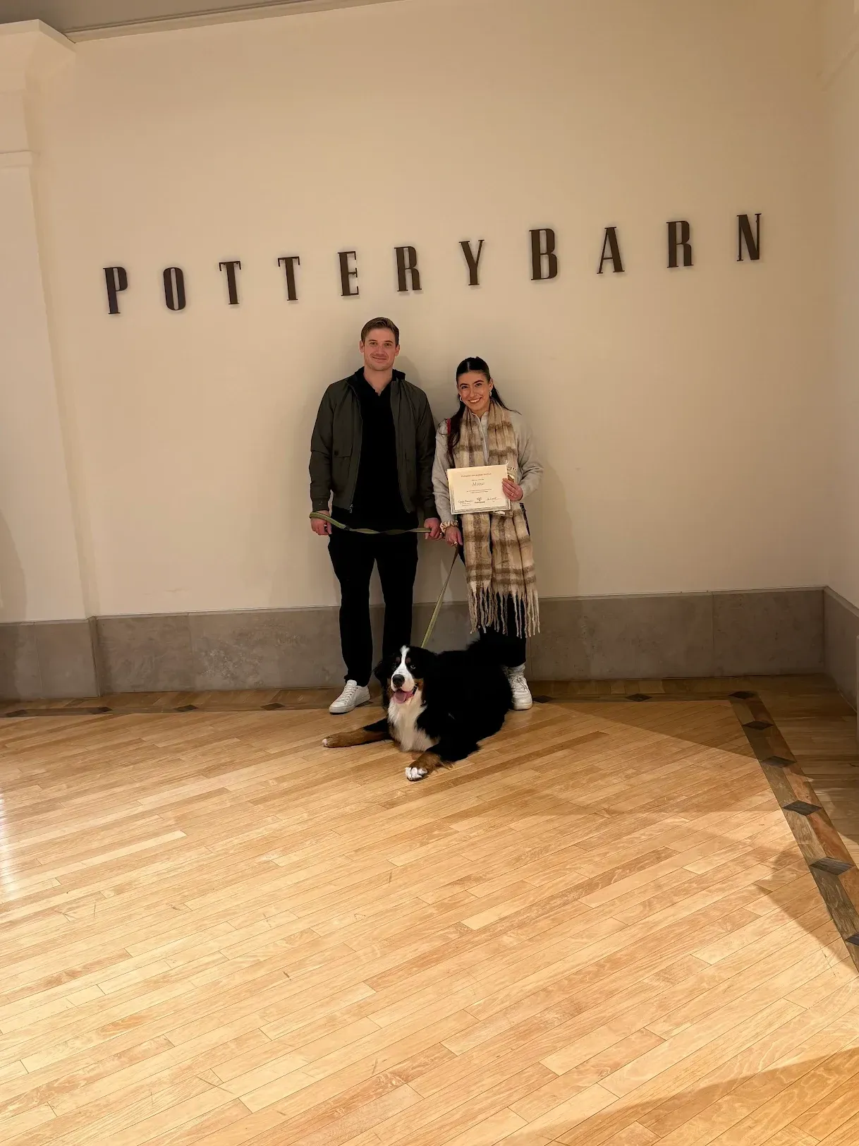 Two people and a dog in Pottery Barn. The dog is on a leash.