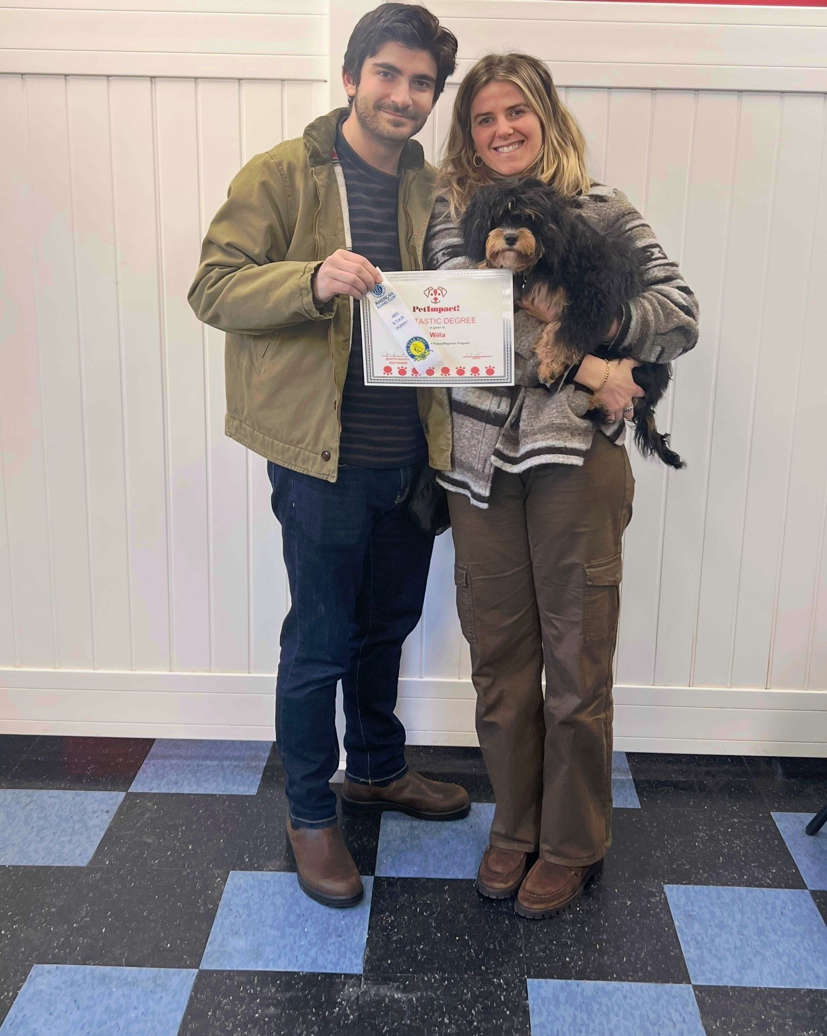 A man and a woman are standing next to each other holding a dog.