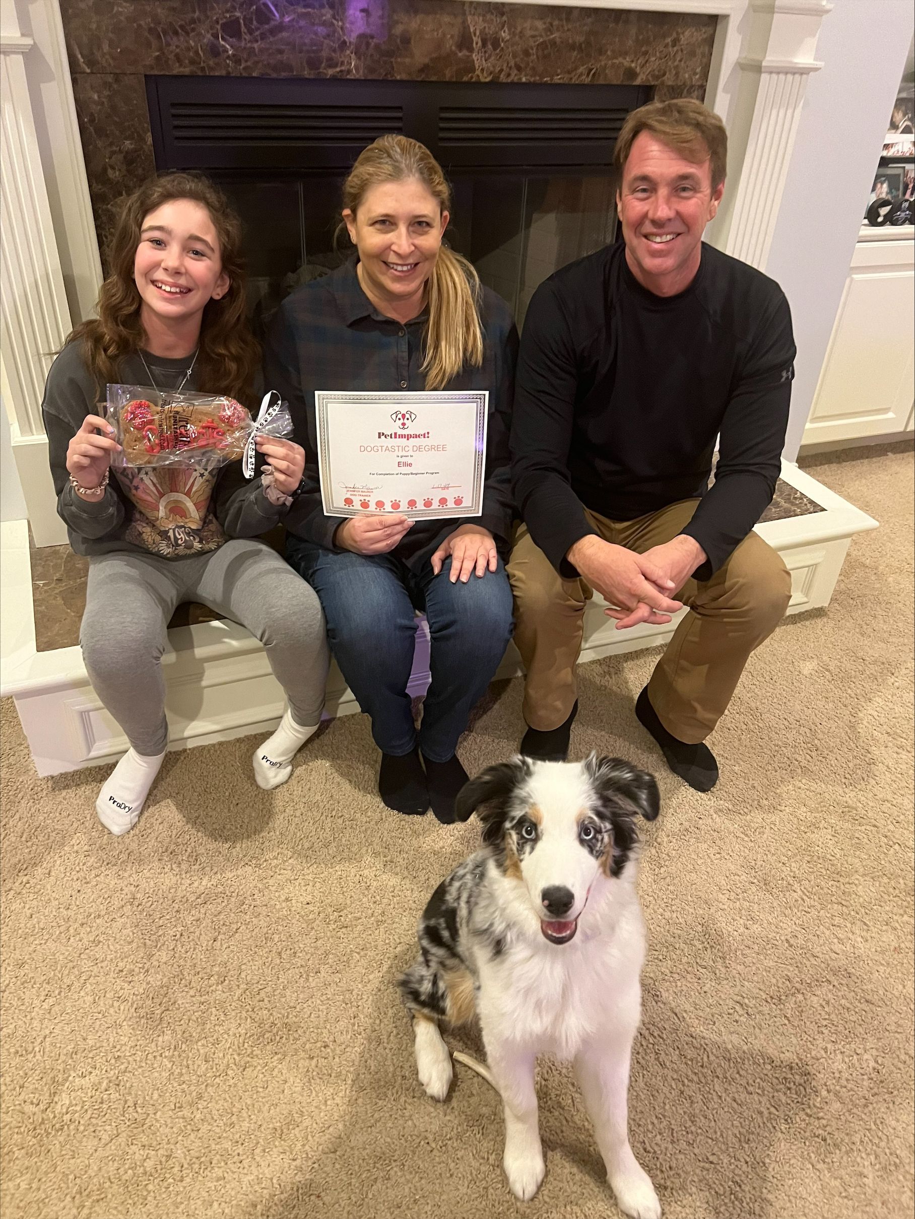 Three Happy Pet Owners Sitting With A Dog — St. Louis, MO — PetImpact!