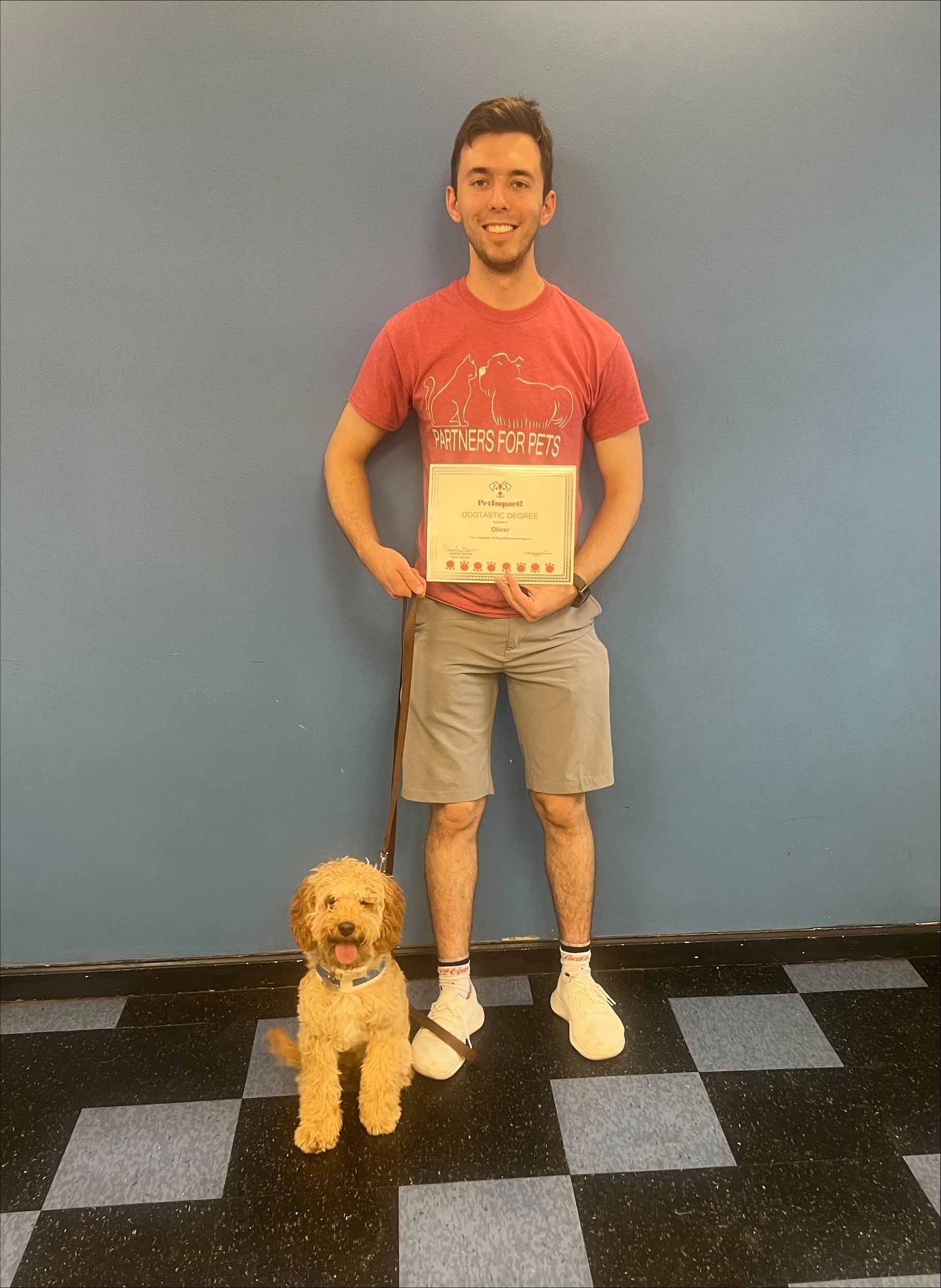 A Man Is Standing Next To A Small Dog And Holding A Sign