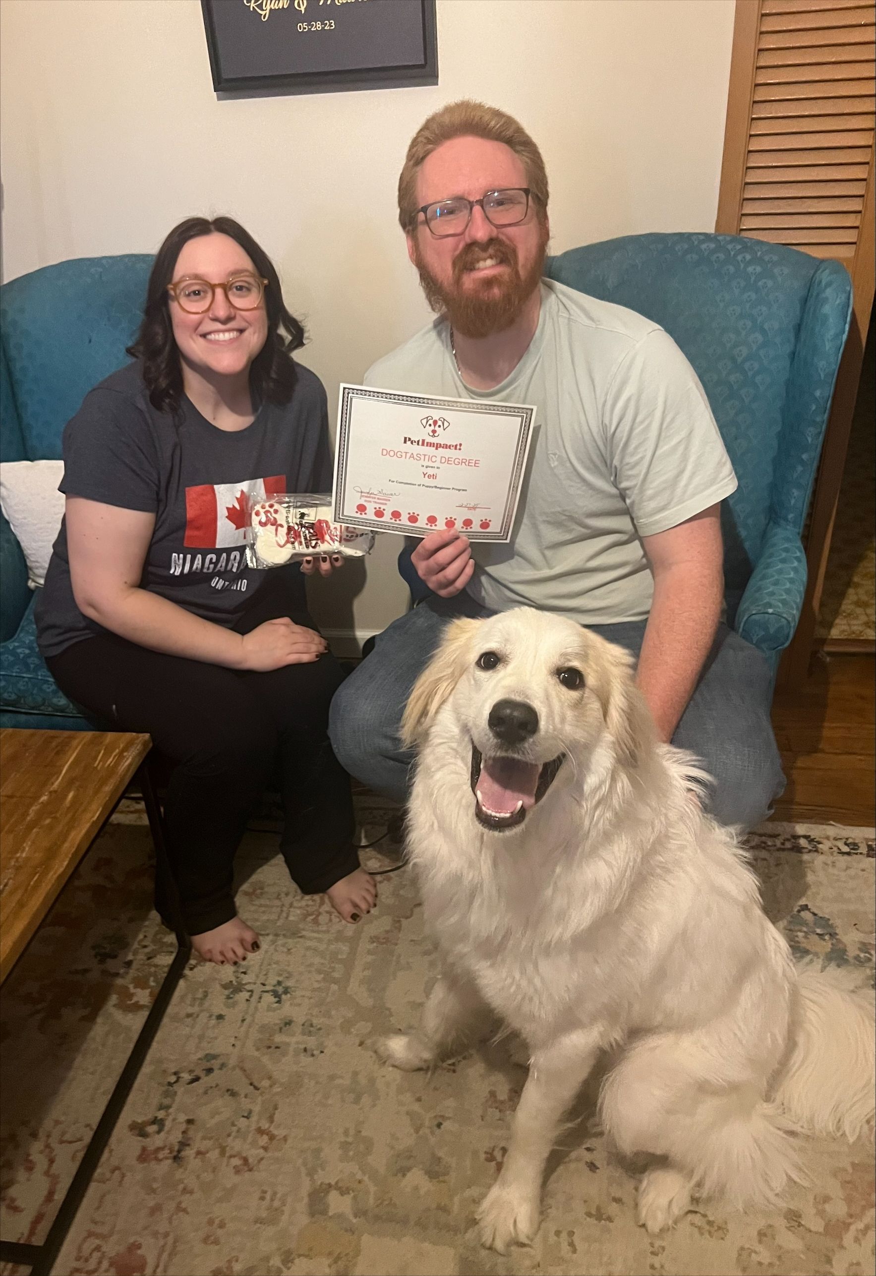 A man and a woman are sitting in a chair with a dog.