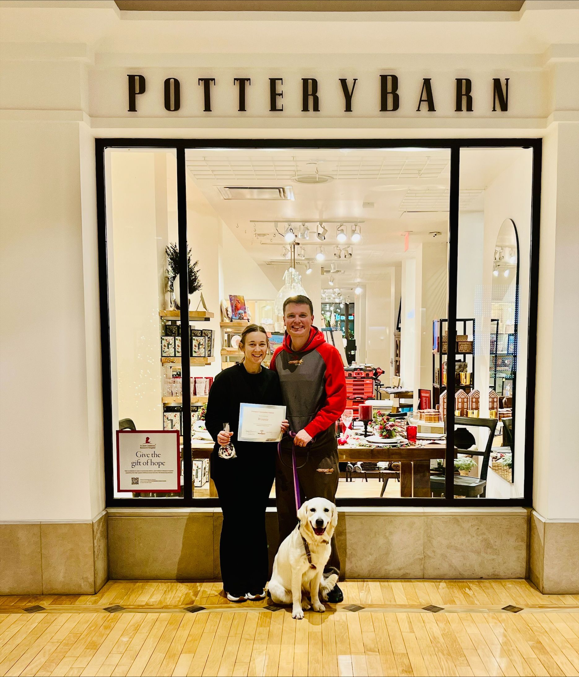 A man and woman standing in front of a pottery barn store