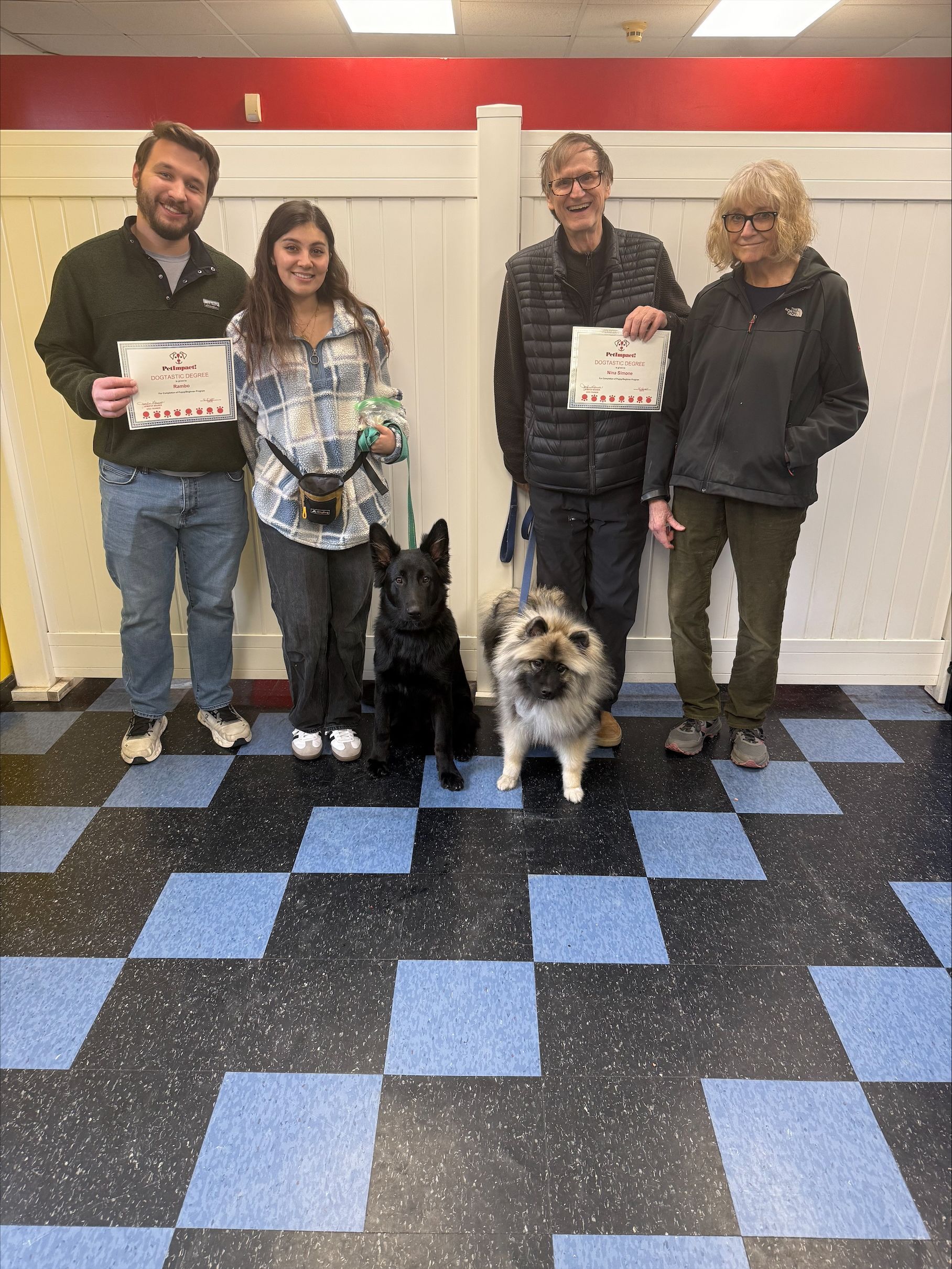 A group of people standing next to each other with their dogs.