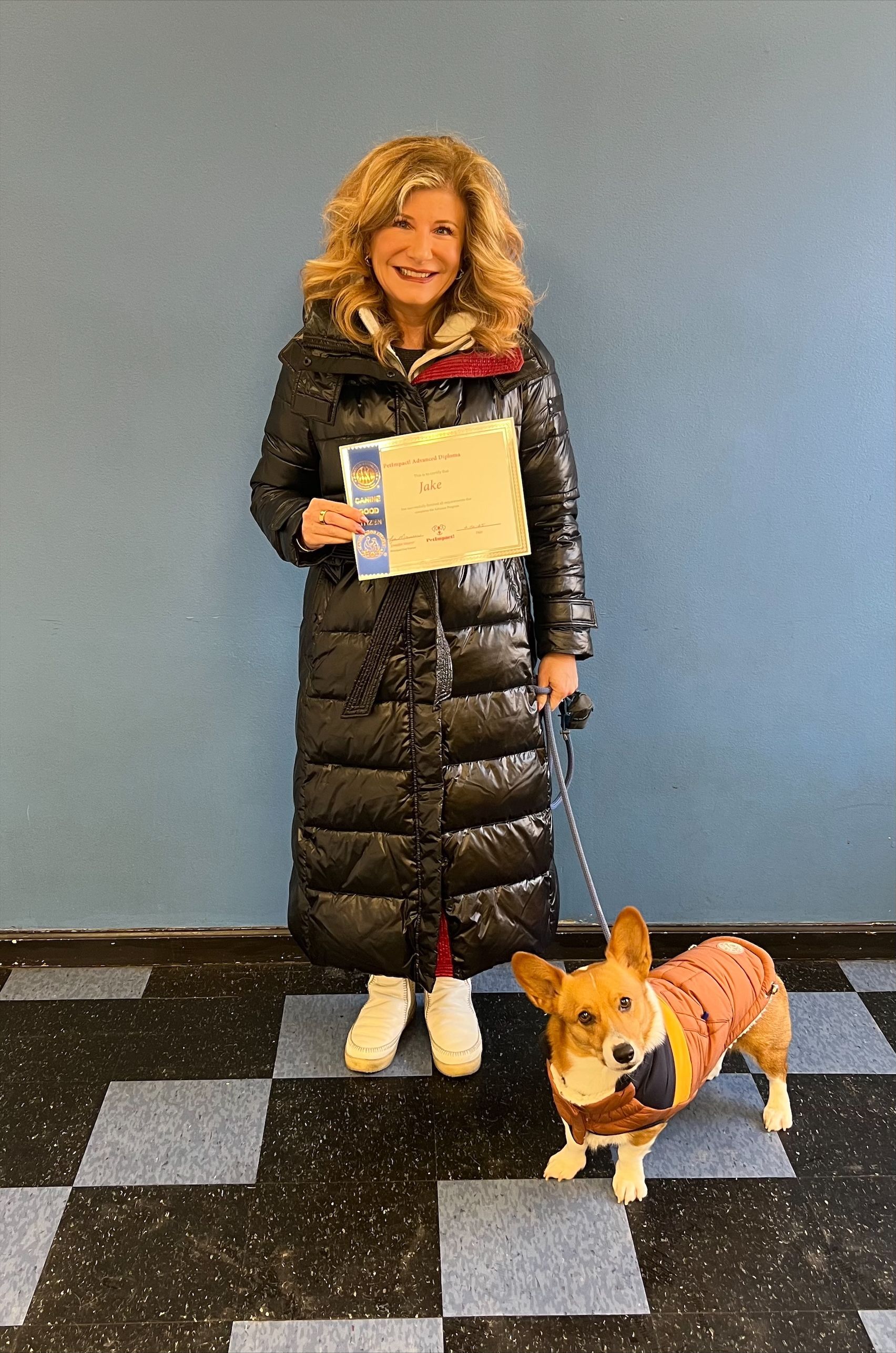 A woman is standing next to a small dog on a leash.