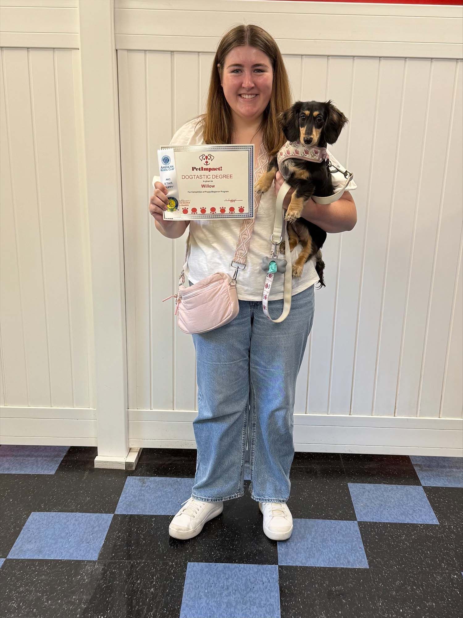 A woman is holding a dog in her arms and holding a certificate.