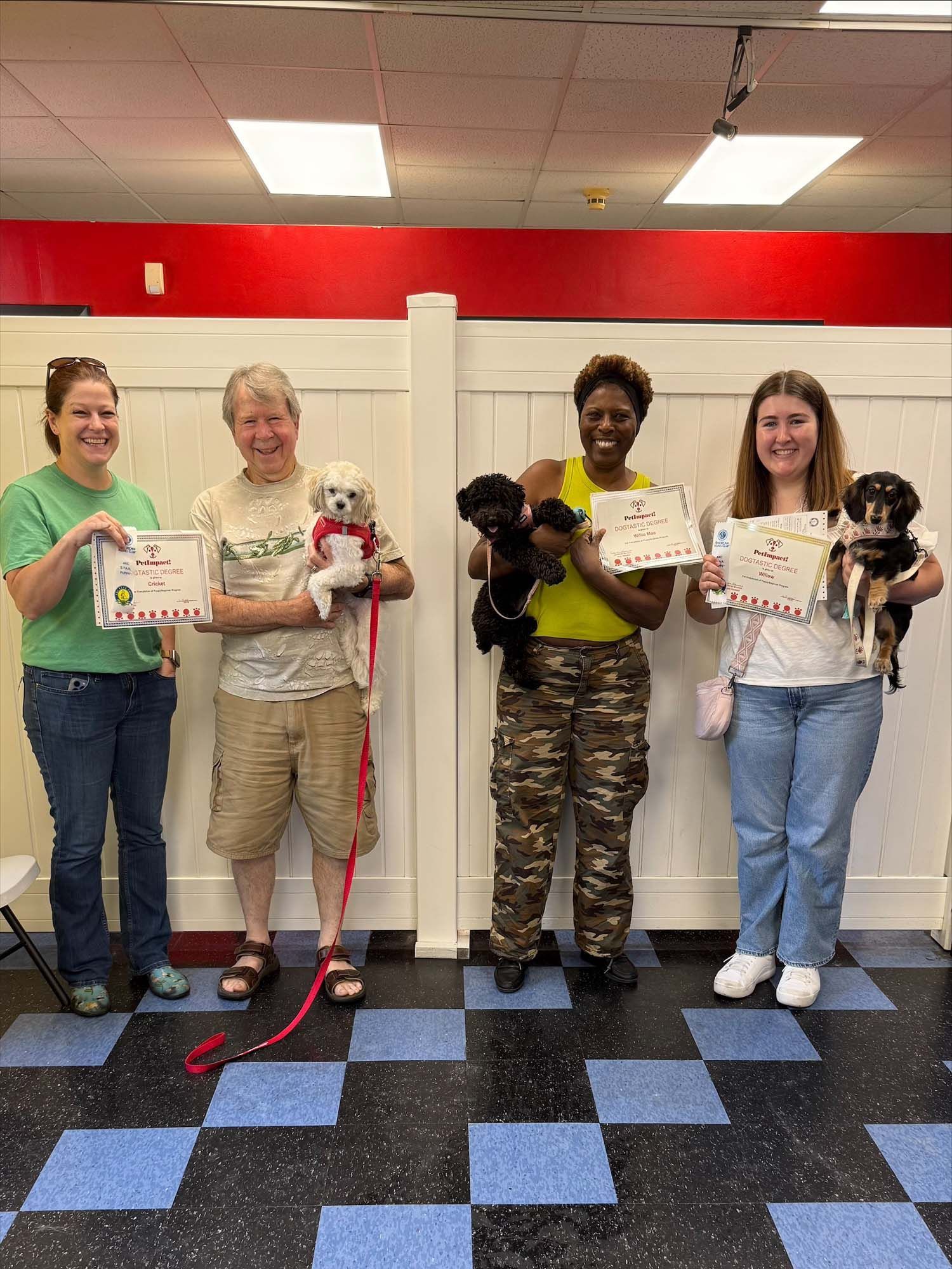 A group of people standing next to each other holding puppies and certificates.