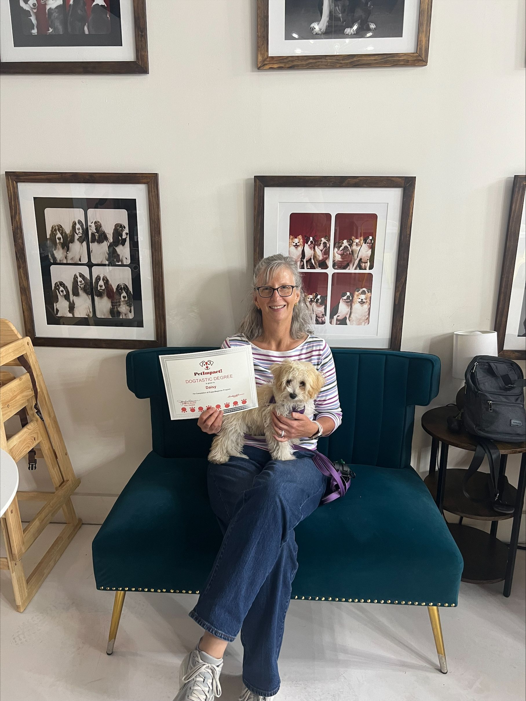A woman is sitting on a couch holding a dog and a cake.