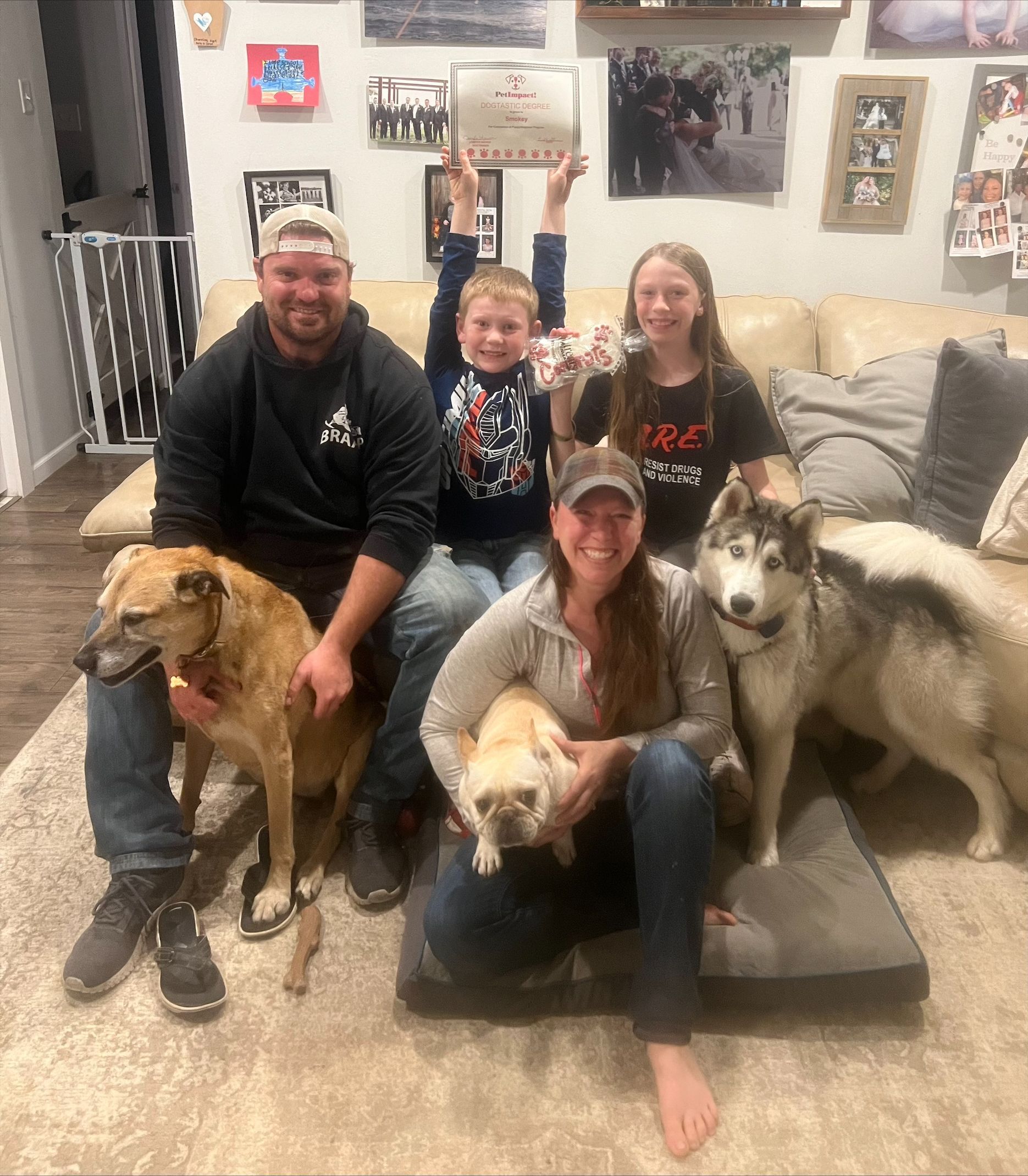A family is posing for a picture with their dogs