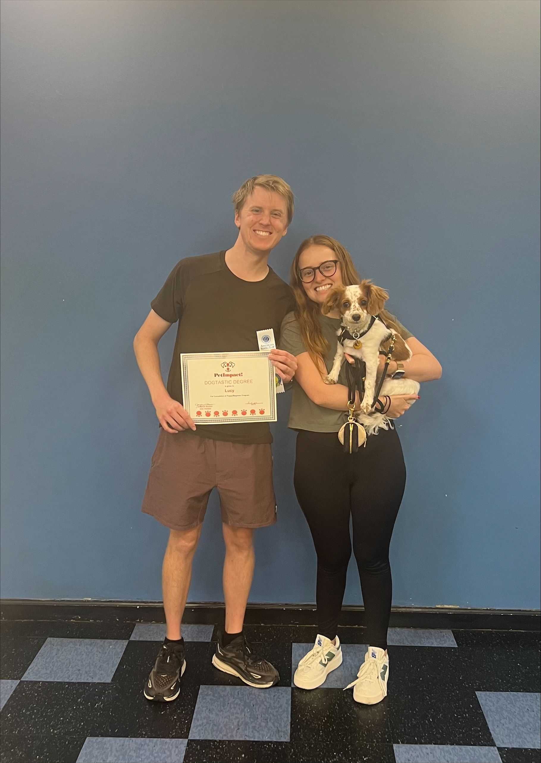 A man and a woman are standing next to each other holding a dog.