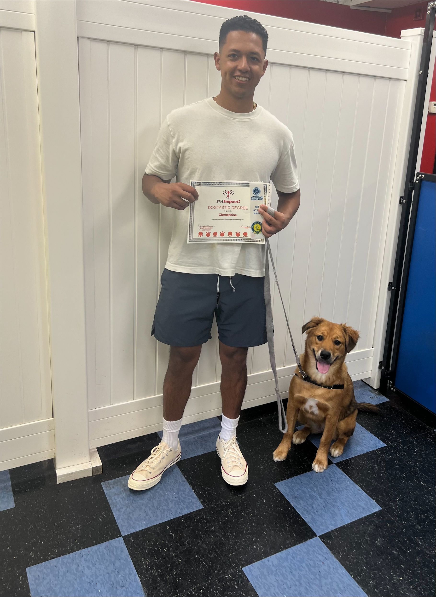 A man is standing next to a dog on a leash and holding a certificate.