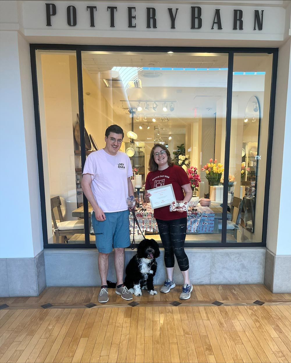A man and woman standing in front of a pottery barn store
