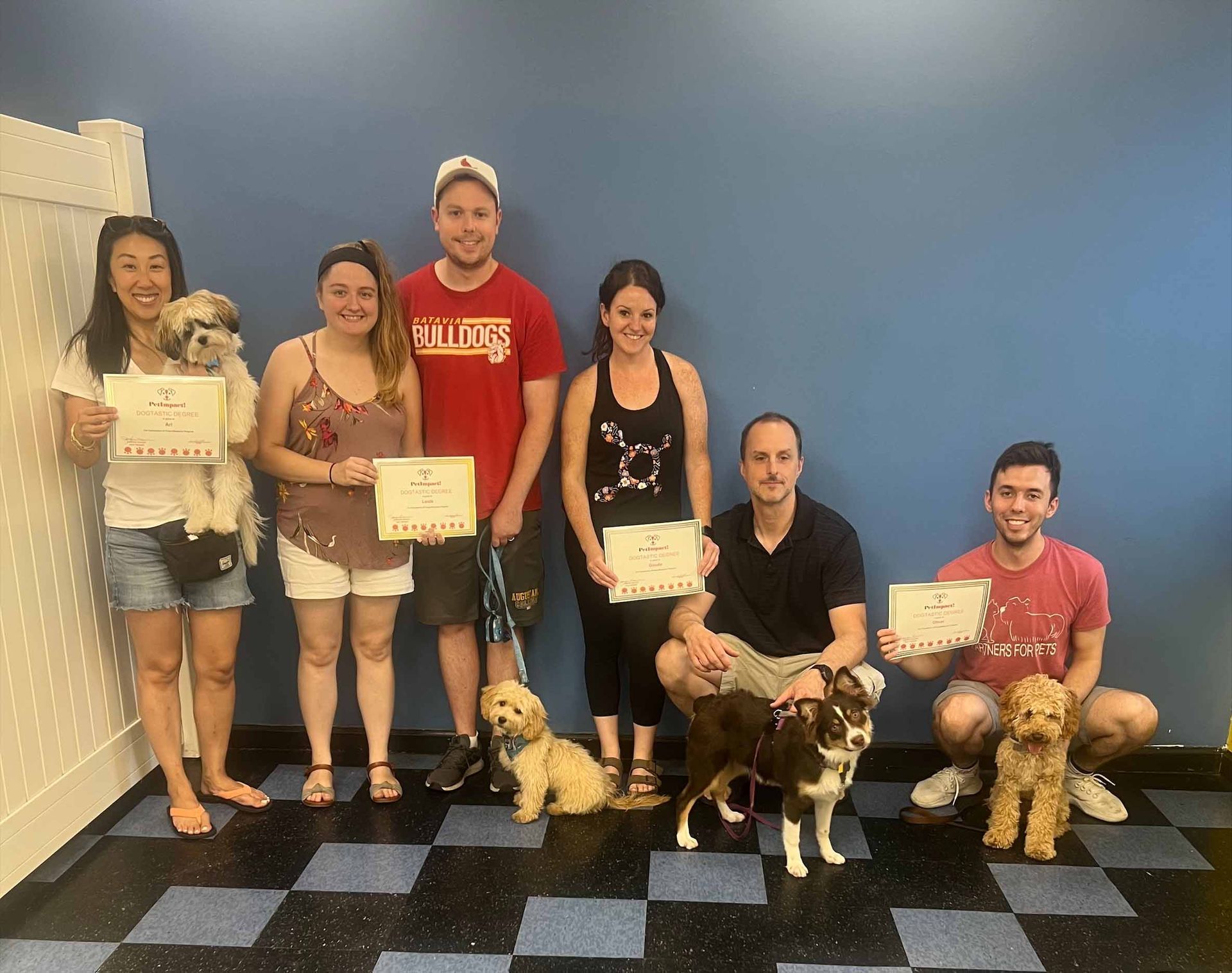 A Group Of People And Their Dogs Are Posing For A Picture