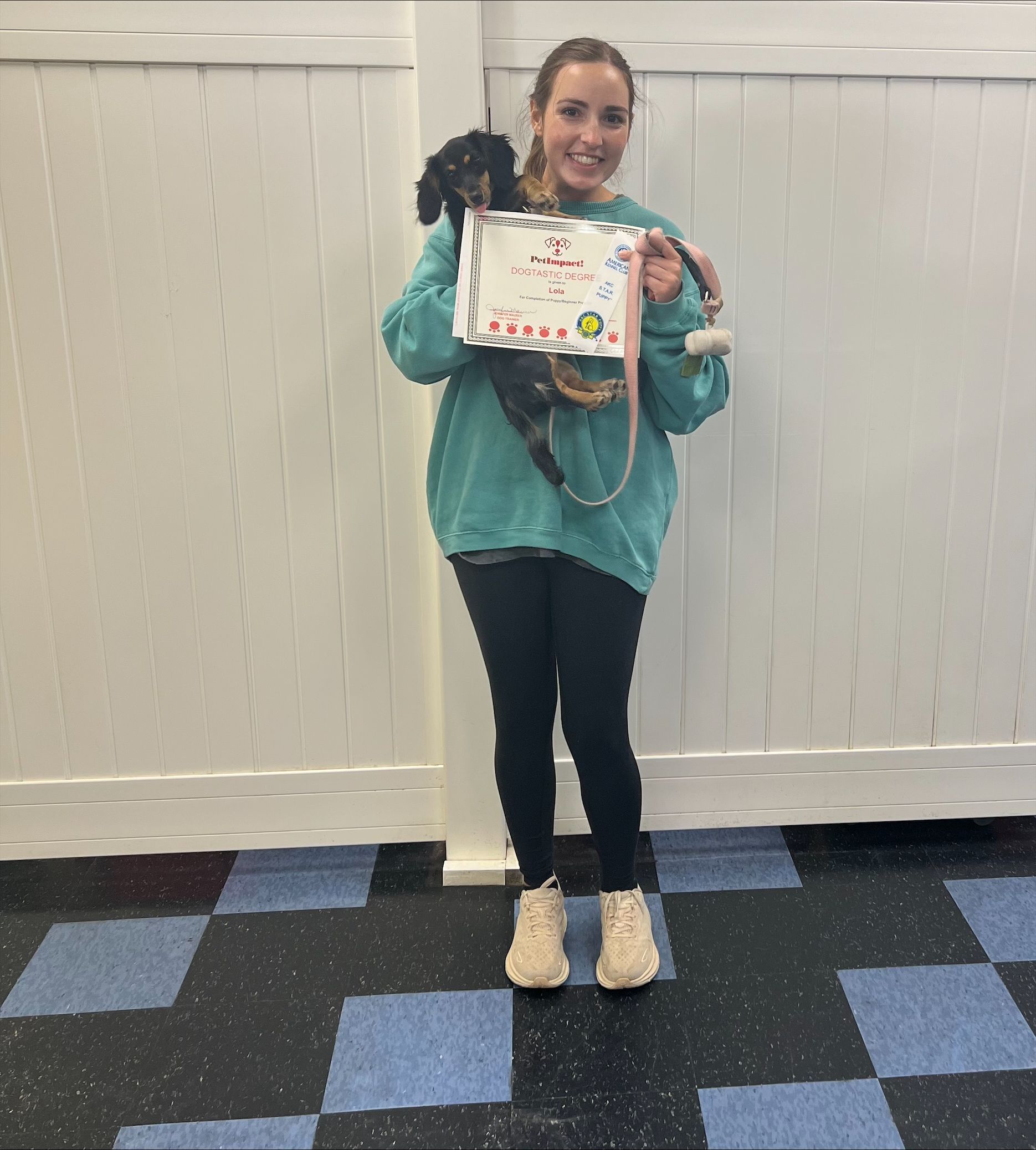 A woman is holding a puppy in her arms and holding a sign.