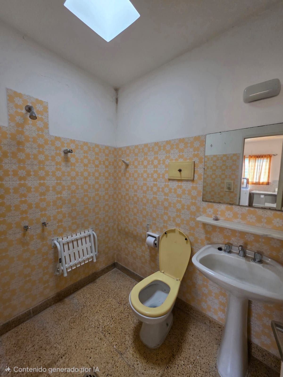 Baño pequeño con azulejos, inodoro, lavabo, espejo, ducha y tragaluz.