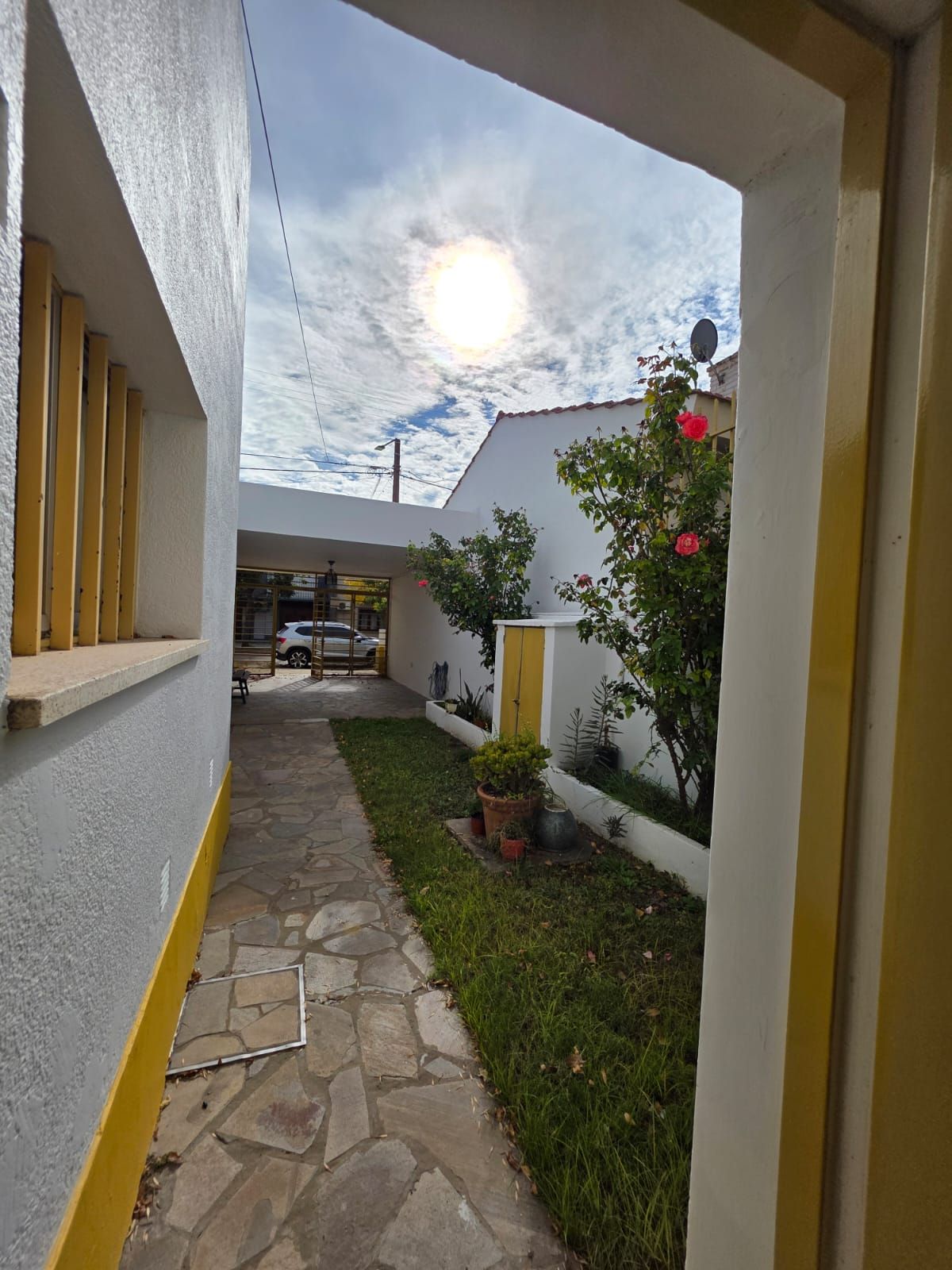 Un estrecho sendero de piedra en un patio de paredes blancas