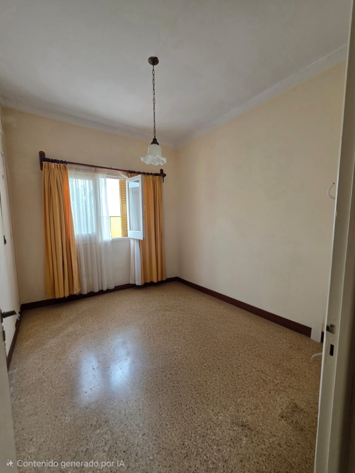 Habitación vacía de color beige con suelo de baldosas, ventana con cortinas amarillas y una lámpara colgante.