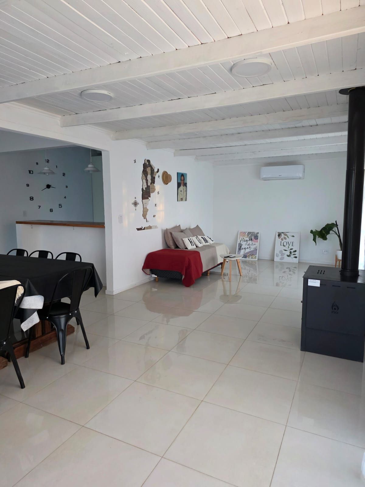 Sala de estar minimalista con suelo de baldosas blancas, sofá rojo